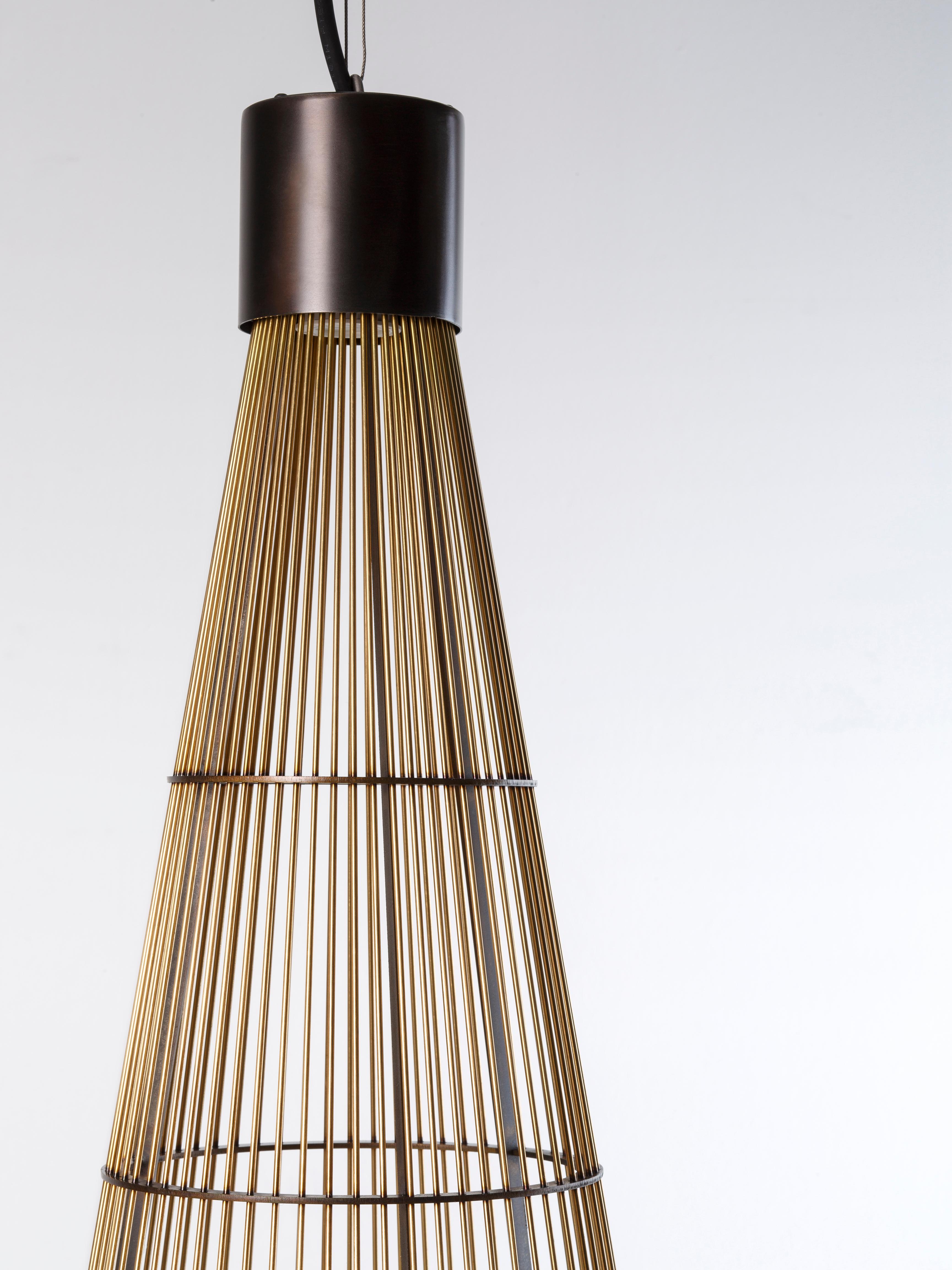 An iron and brass cone forms a sunburst to outline and expand light, defining its consistency, exploring new formal boundaries. Luce Solida is a lightweight lamp, built around a ‘shade’ made of small metal rods placed side by side, dematerializing