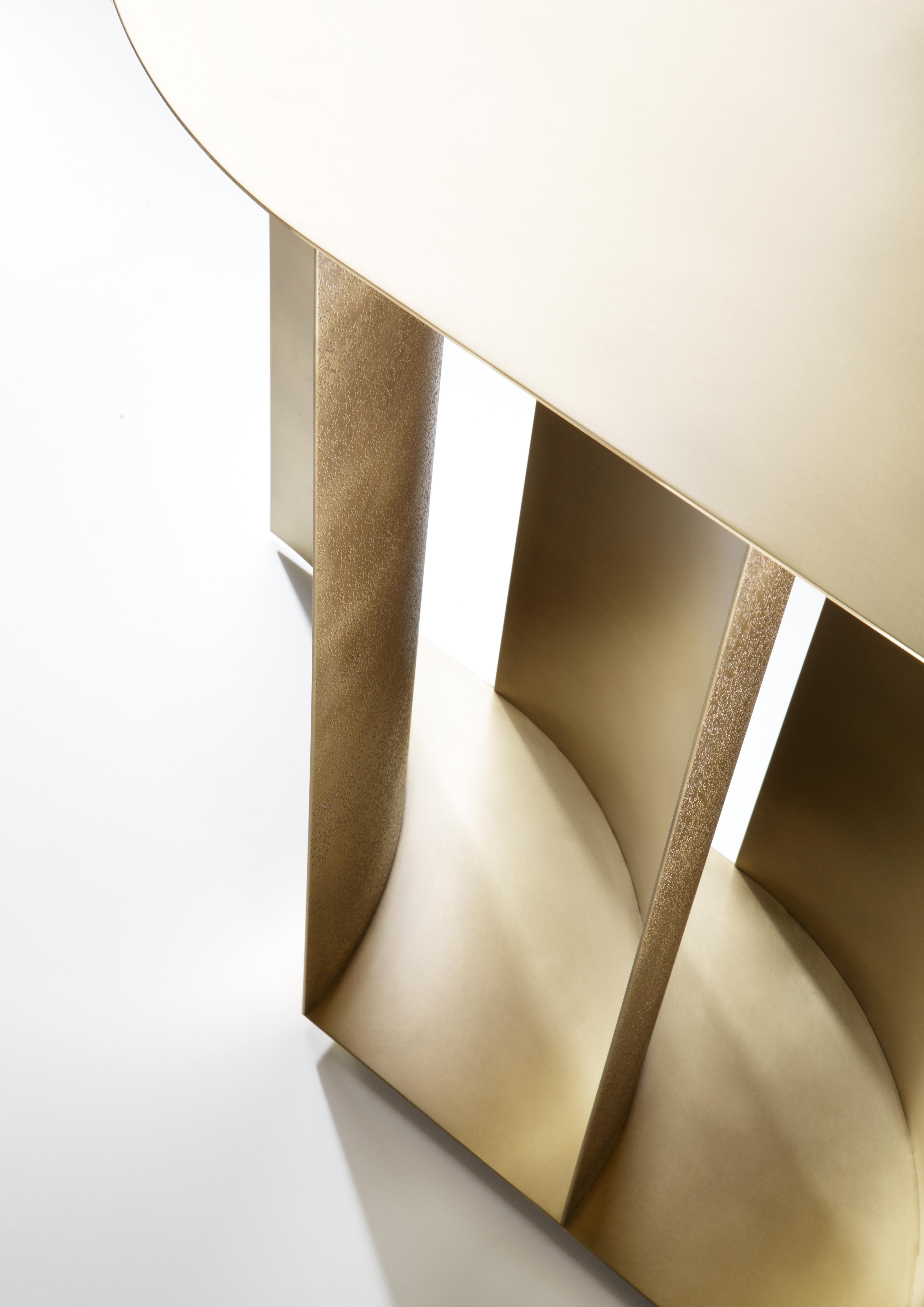 A series of curved brass sheets form the base of Sinestesia encapsulating the solidity and expressiveness of metal.
With rounded edges, the leaf-like top of the console rests on the curvature of the metal sheets below, playing with positive and