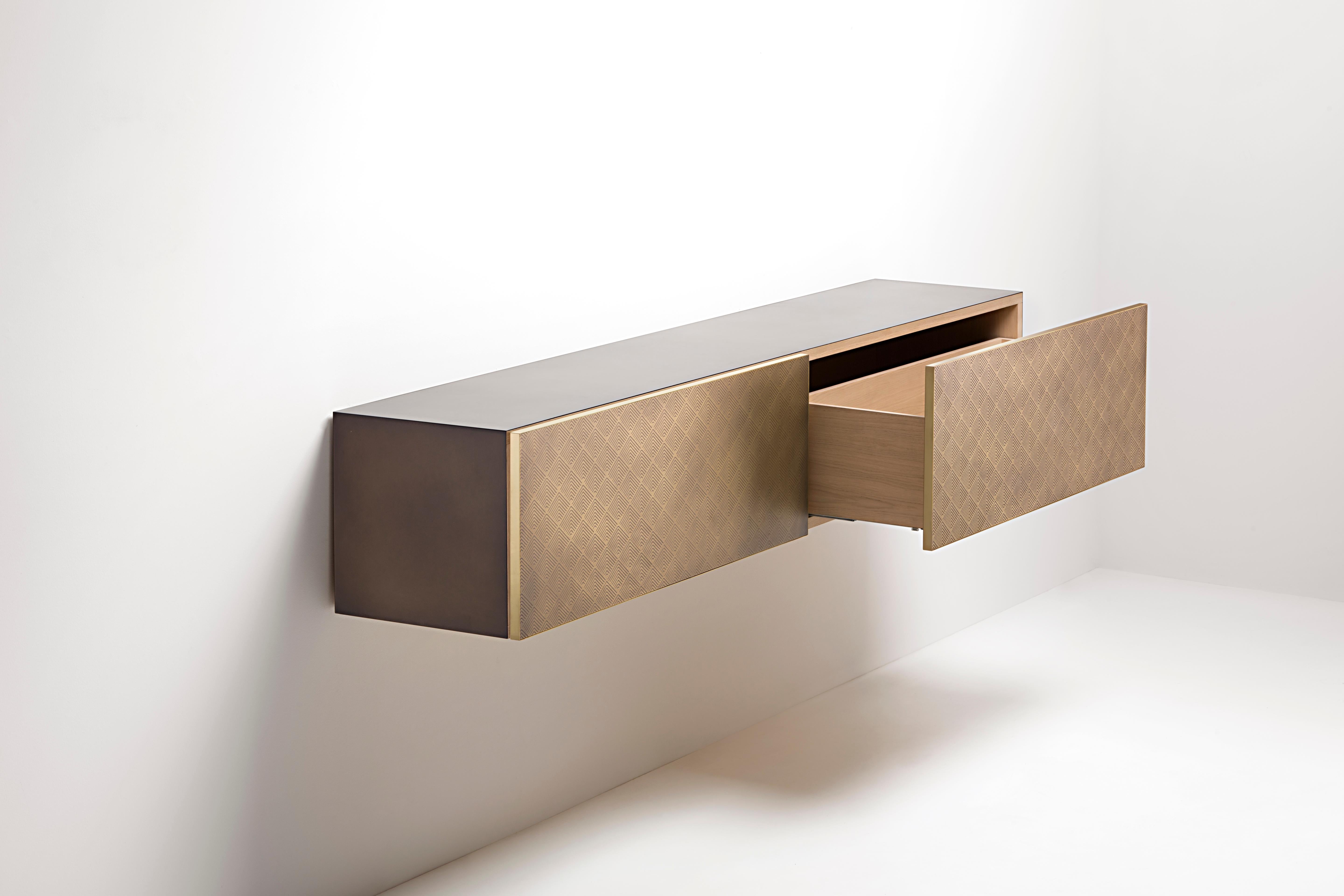 Volumi puliti per una consolle dalle linee piuttosto semplici, che mettono in risalto la nobiltà dei metalli che rivestono le grandi facce dei cassetti. Disponibile sia nella versione a sospensione che in quella free-standing, Tako evoca la delicata