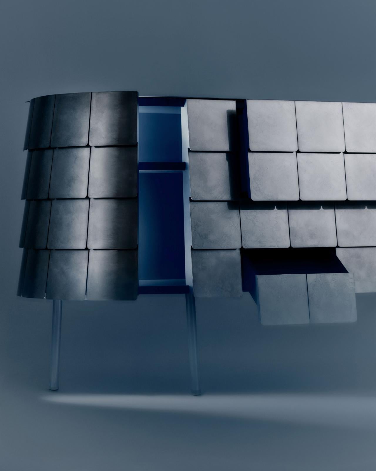 Come le dure lastre di metallo che identificano l'armatura di un samurai, le squame sulla pelle di questo pezzo ne definiscono l'aspetto. Yoroi ha una forma dinamica, che riprende la forza evocativa degli arredi Art Deco, gioca con l'essenzialità di
