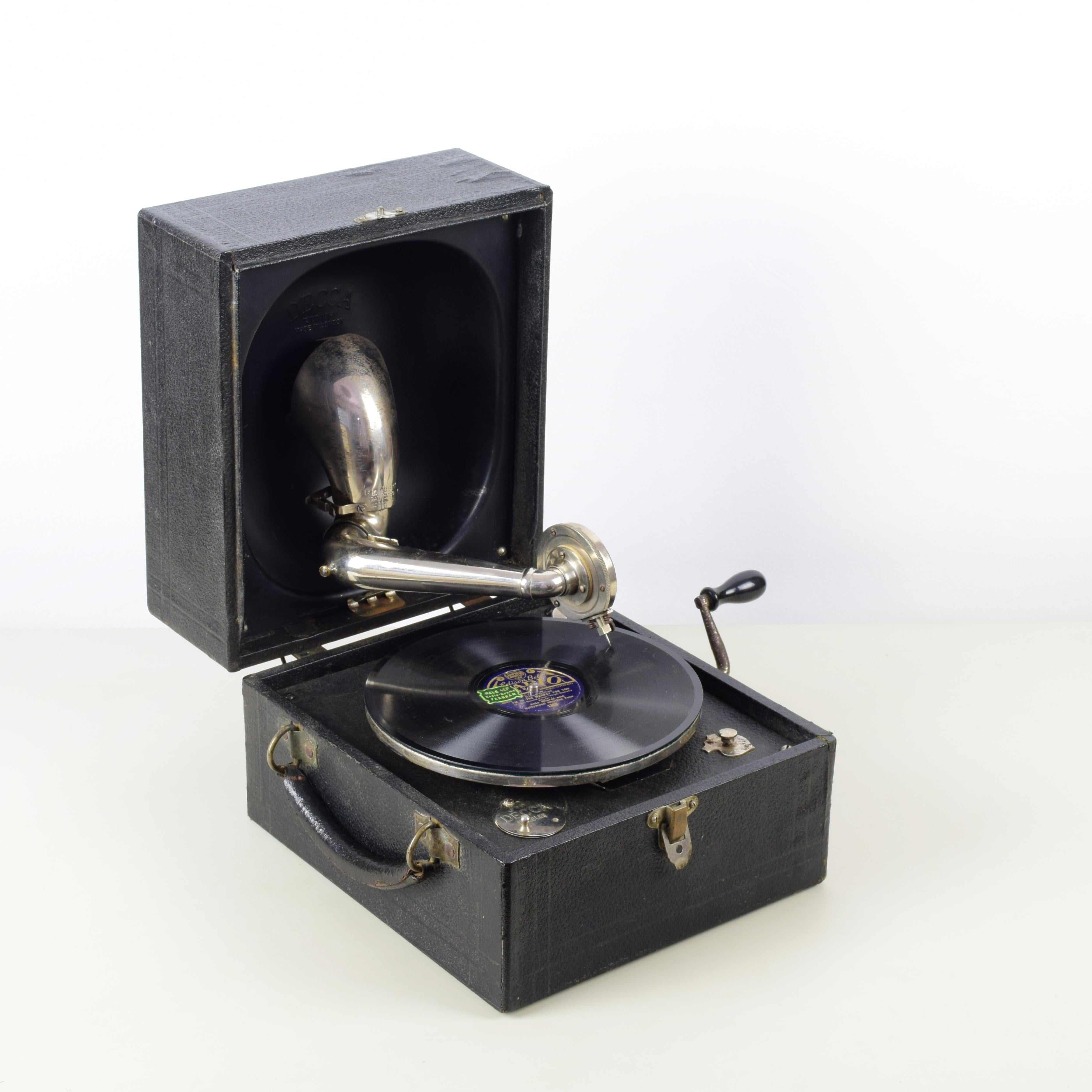 Decca Junior 'Trench' portable gramophone, 1923

Black vinyl case, black painted parabolic reflector, nickel plated steel components and fittings.
Original Crescendo junior soundbox.
Good original condition. General wear in accordance with age.