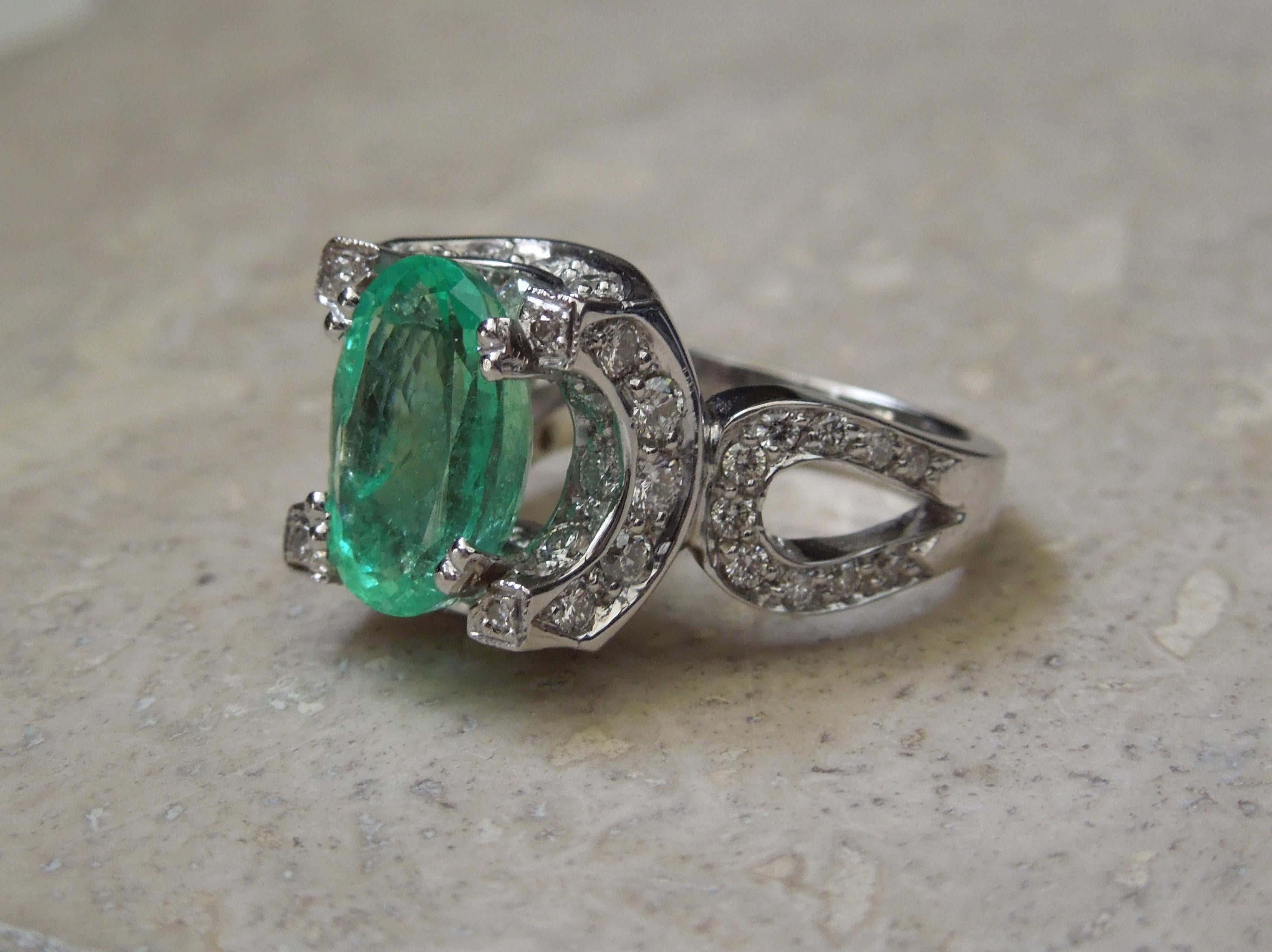 In a concave Halo design, this Emerald Ring is attributed to the Retro Art Deco period, in a European inspiration. Intricately fabricated, yet secure and durable in a heavily constructed design to ensure durability. Featuring a central 5 carat Oval
