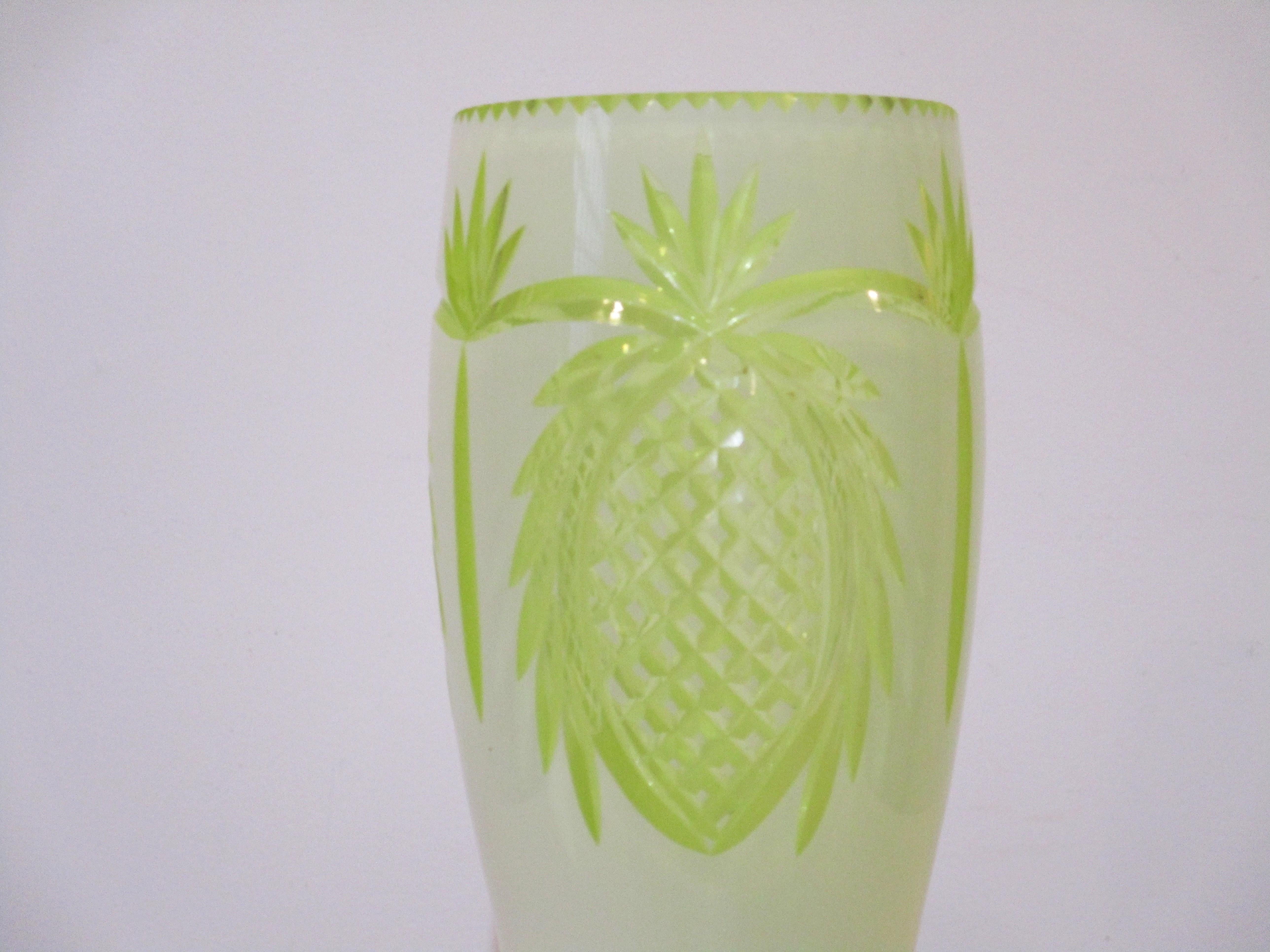 Un très joli vase en verre de Bohème taillé et poli à la main, de couleur blanc crème et citron. Ce vase représente des ananas et des palmiers, ce qui est très différent du verre de Bohème typique que nous avons vu. De superbes découpes dans le haut