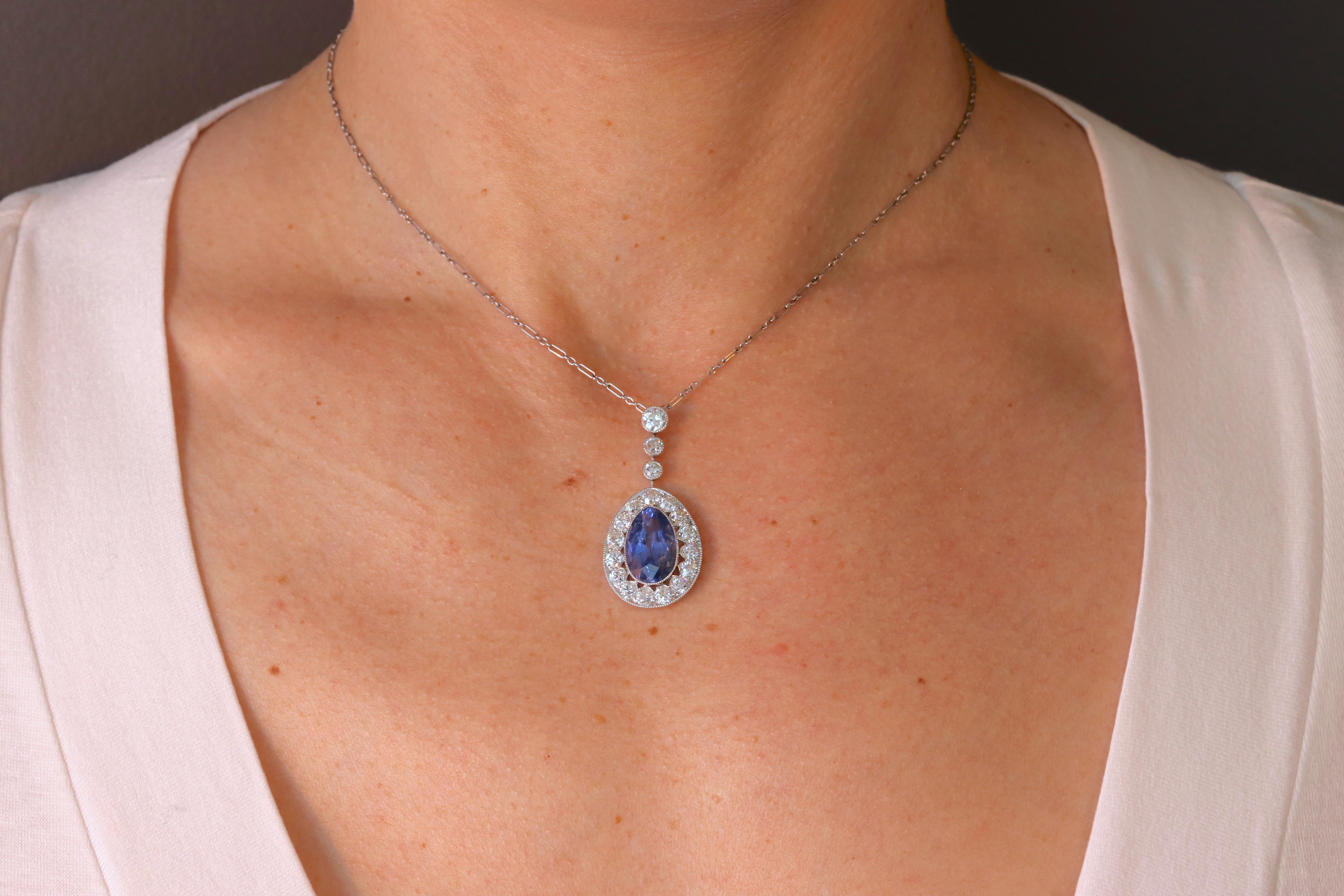 A stunning Art Deco pendant featuring an approximately 5.74 Carat Burma No Heat Blue Sapphire as designated by the Gemological Institute of America GIA, masterfully set among a large halo of approximately  2.27 carats of G-H color and SI1+ Old