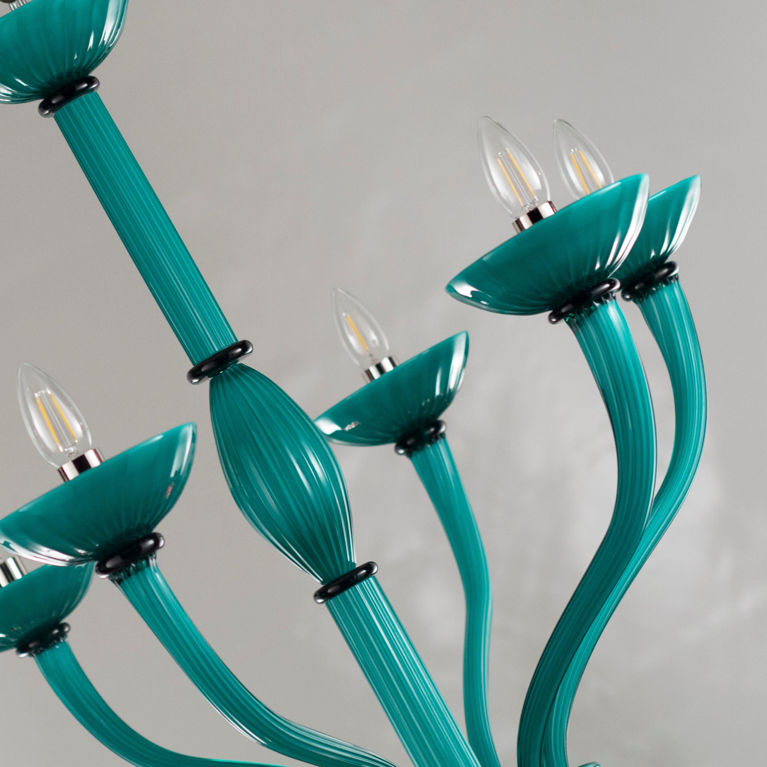The blown glass Velvet Venetian chandelier is inspired from the Art Deco style. It is characterized by long arms which are bended upwards and by encased coloured glass, which confers a peculiar texture to the material.
The sinuous design, the shades