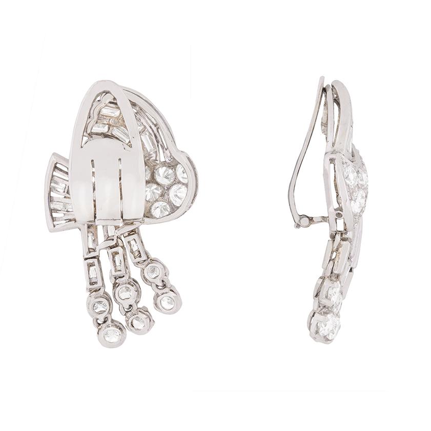 With the original fitted box, these breath-taking earrings are simply stunning. In total, they have a weight of 4.80 carat and are made up of transitional cut diamonds and baguette cuts. The extravagant design helps us date the piece to the 1930s,