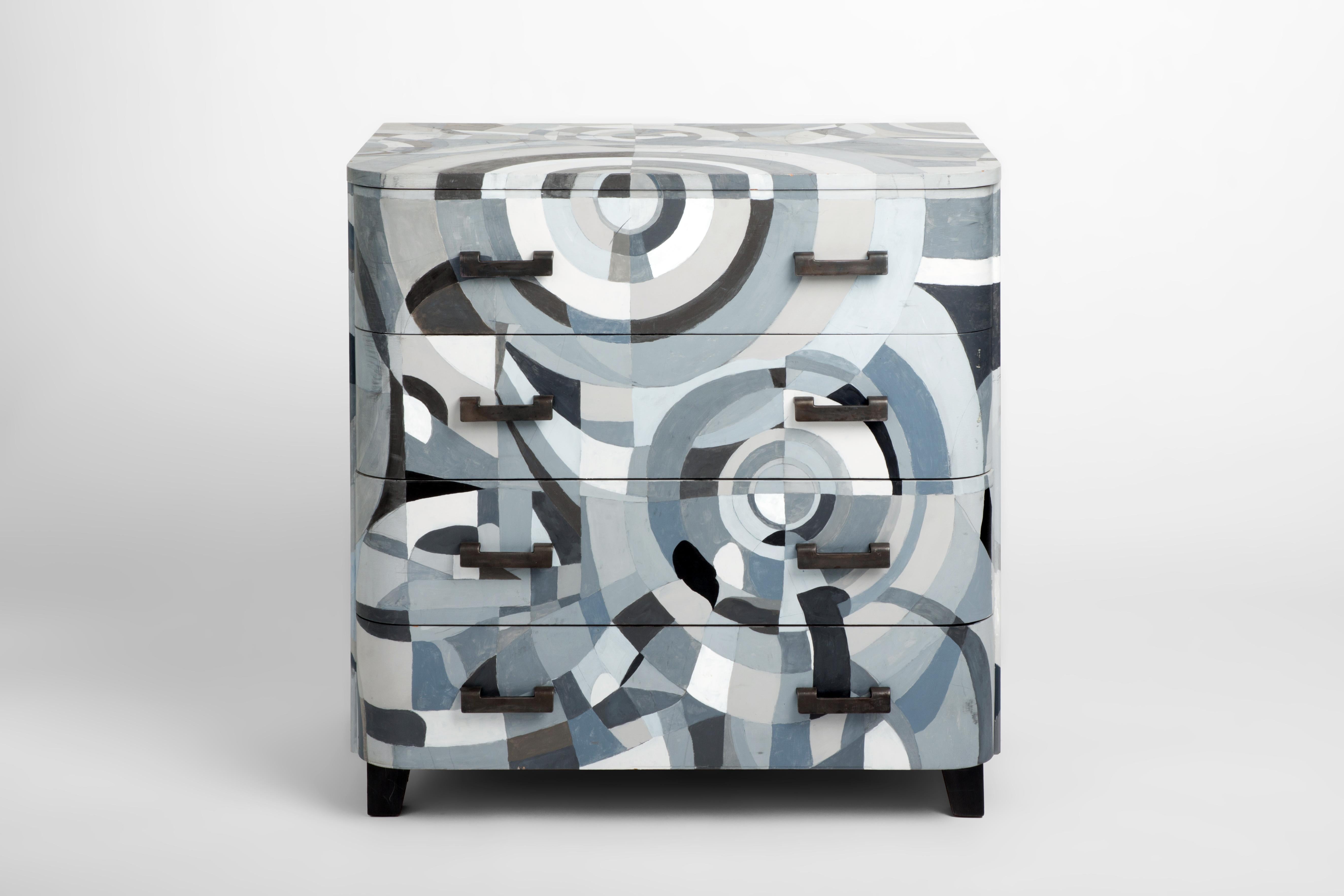 A simple midcentury cabinet with curved corners reminiscent of Art Deco forms is re-imagined by decorative painter Dean Barger, who adapted a Sonia Delaunay painting, wrapping the piece in the cool gray tones of a undulating and geometric pattern.
