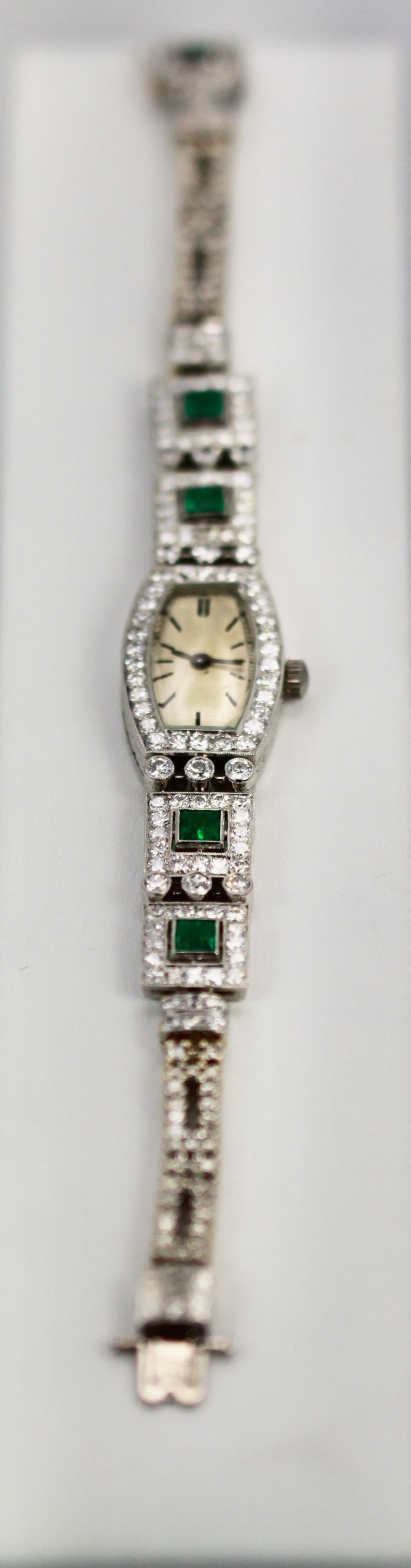 Diese wunderschöne Deco Emerald Platinum Damenarmbanduhr ist aus den 1920er bis 1930er Jahren und hat österreichische Punzen.  Ich mochte die Deco- und Retro-Epoche, weil die Damenuhren alle mit Edelsteinen besetzt waren und wie Armbänder aussahen.