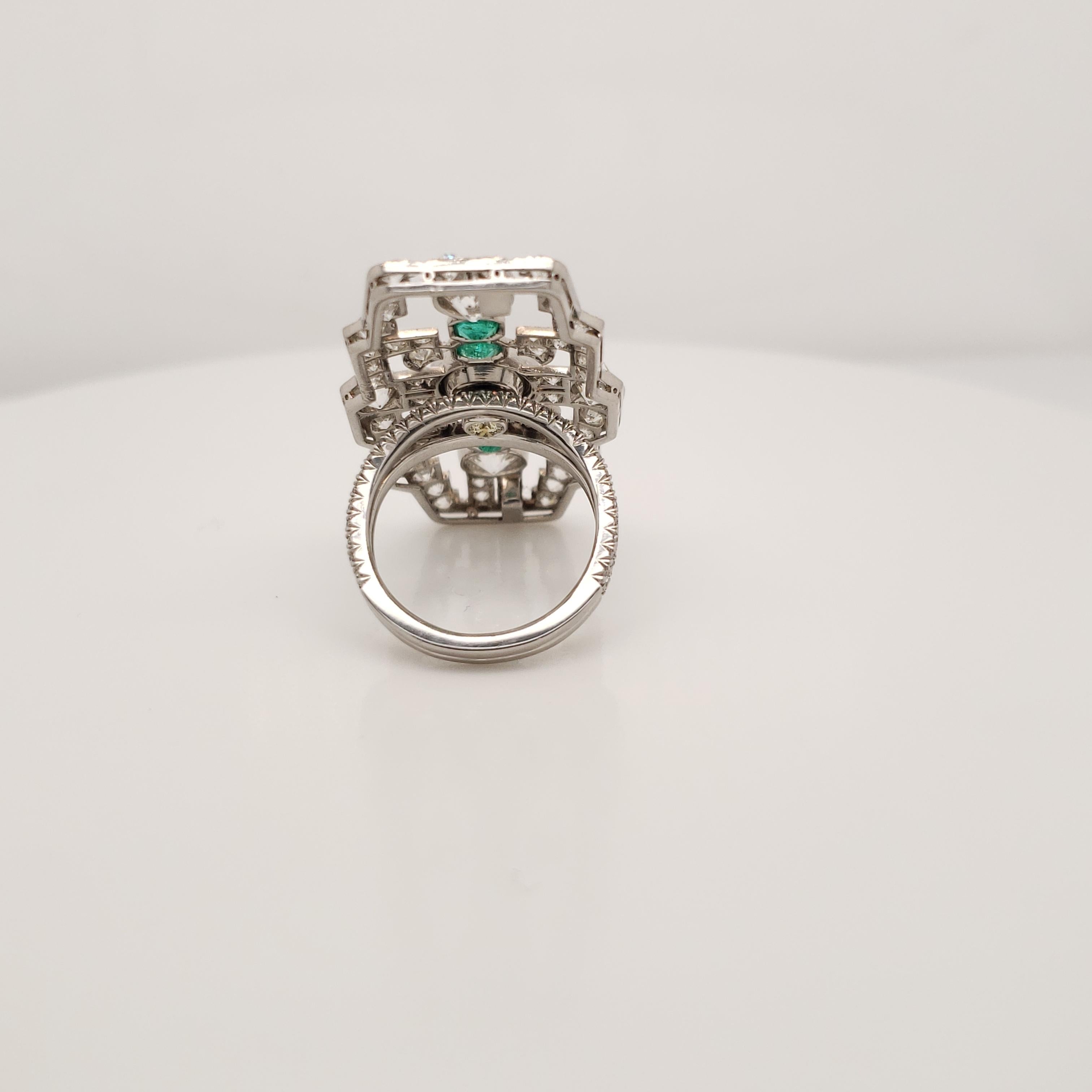This large Diamond and Emerald Statement Ring contains a 1 GIA certified, Round Brilliant Cut, Fancy Deep Greenish Yellow diamond weighing 1.76 carats.
It is mounted with four emeralds, and Old Mine Round diamonds weighing a total of 5.99 carats.
It