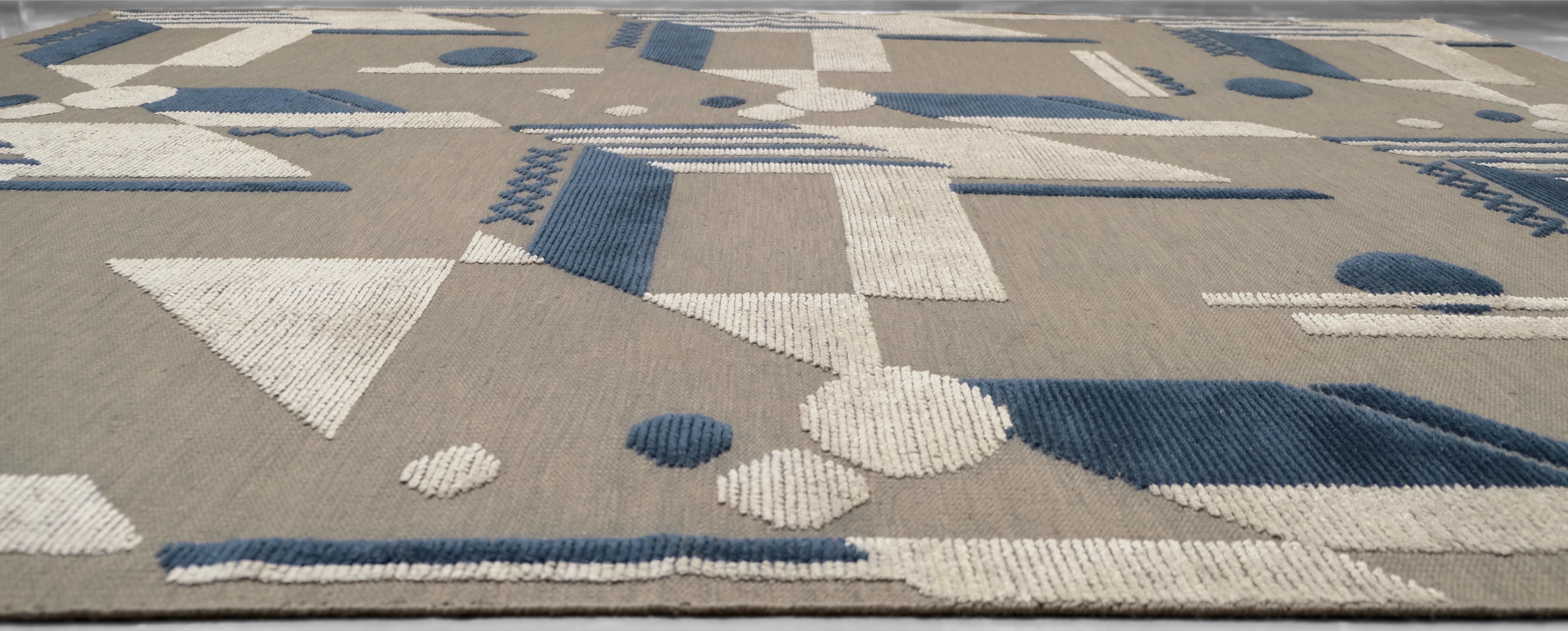 Elevate your space with this contemporary geometric wool and bamboo rug, with exceptional artistry and precision. Featuring a modern architectural pattern in blue, ivory, and taupe tones, this rug combines abstract geometry with a bold yet balanced