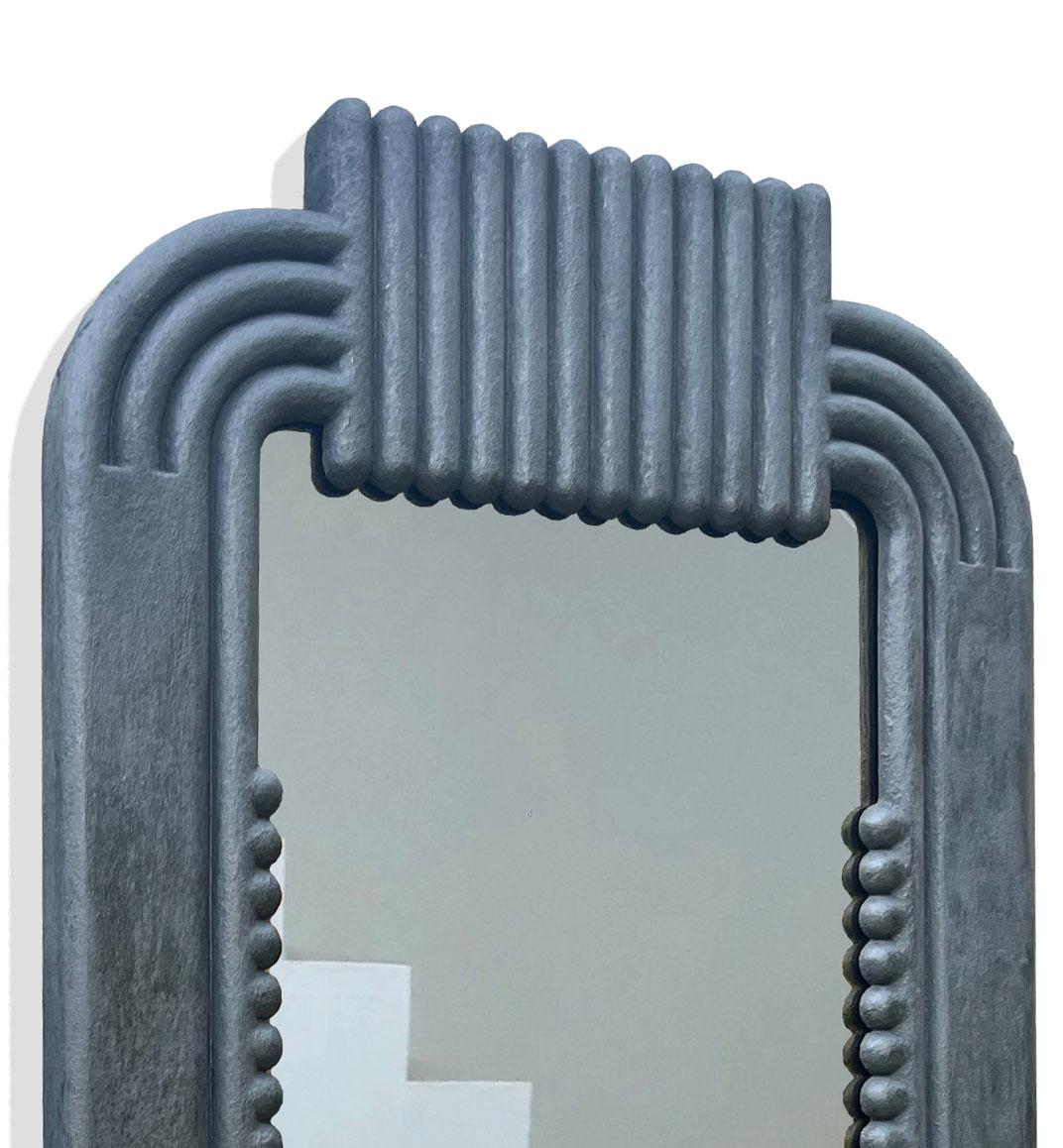This minimalist hand-cast reinforced gypsum mirror is a top-quality Ian C.R. Martin Studio piece. It features a striking, concentric design using a backcasting method that integrates the mirror seamlessly into its plaster frame.  The plaster is