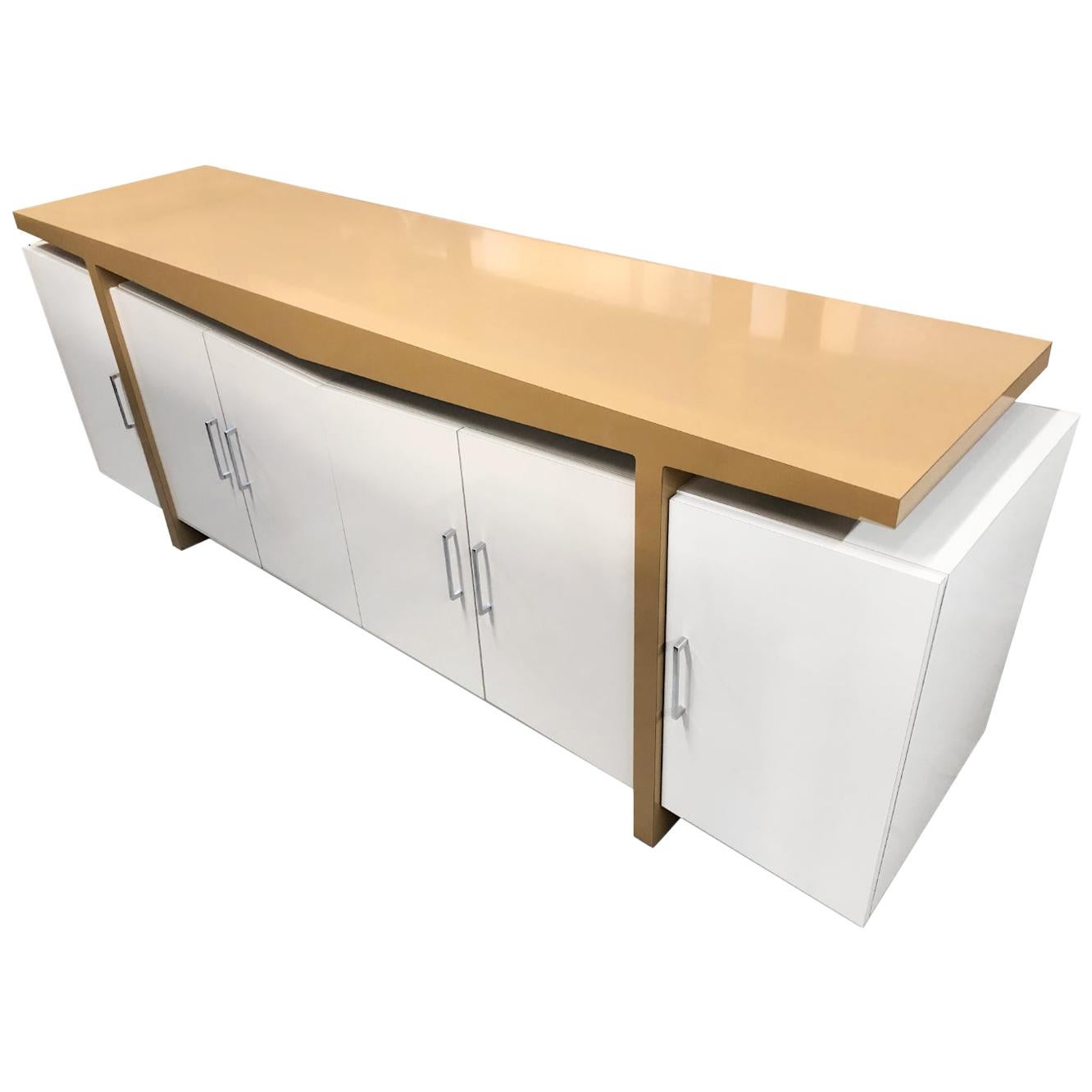 This nearly seven foot long custom made white and beige modern credenza is a real showstopper! If the shear size does not impress you, the architectural form will. The floating top surface is evocative of Frank Lloyd Wright. The sharply tailored