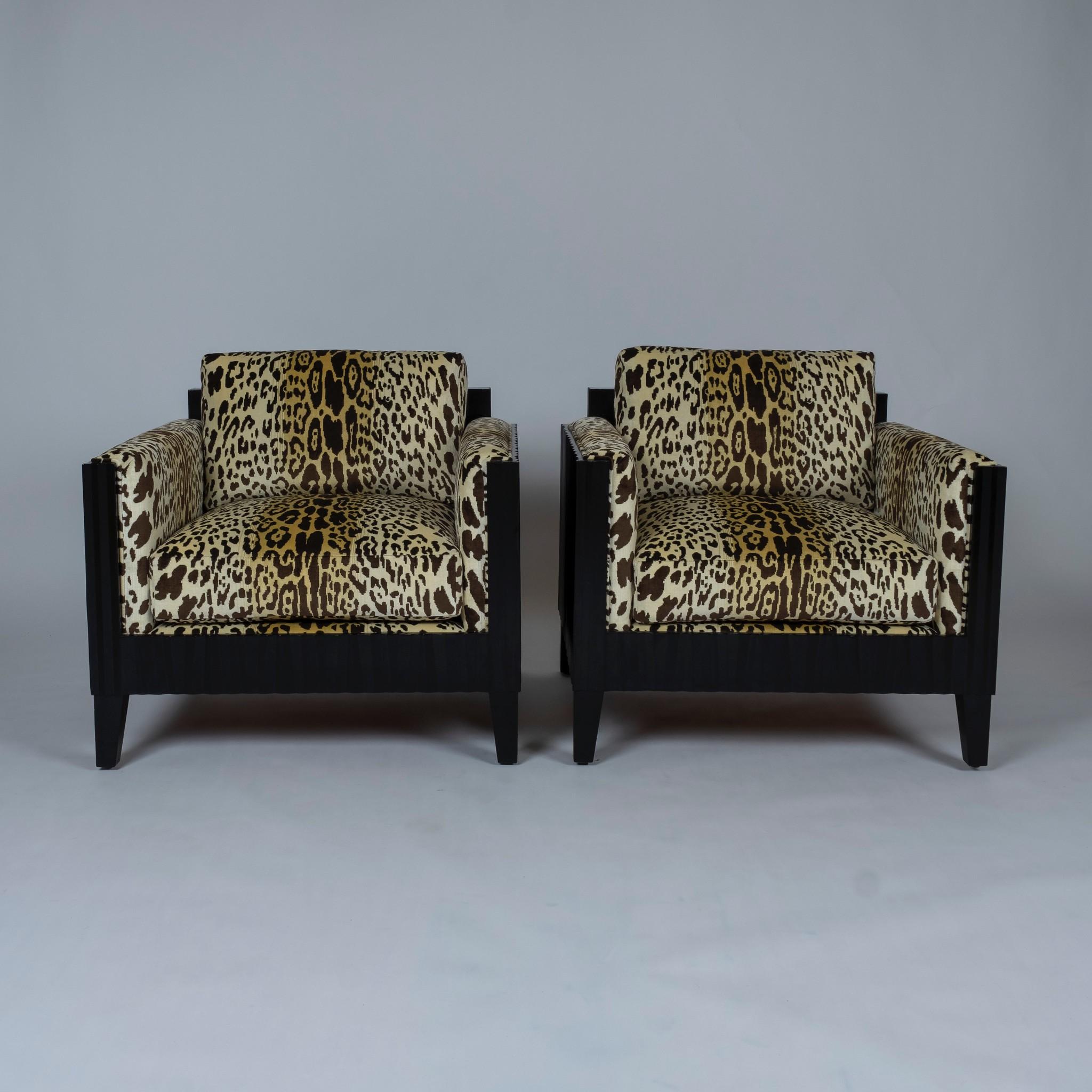 A chic pair of deco style black club chairs newly upholstered in French Nobilis Velours leopard. Seats are feather down wrapped spring coil cushions.