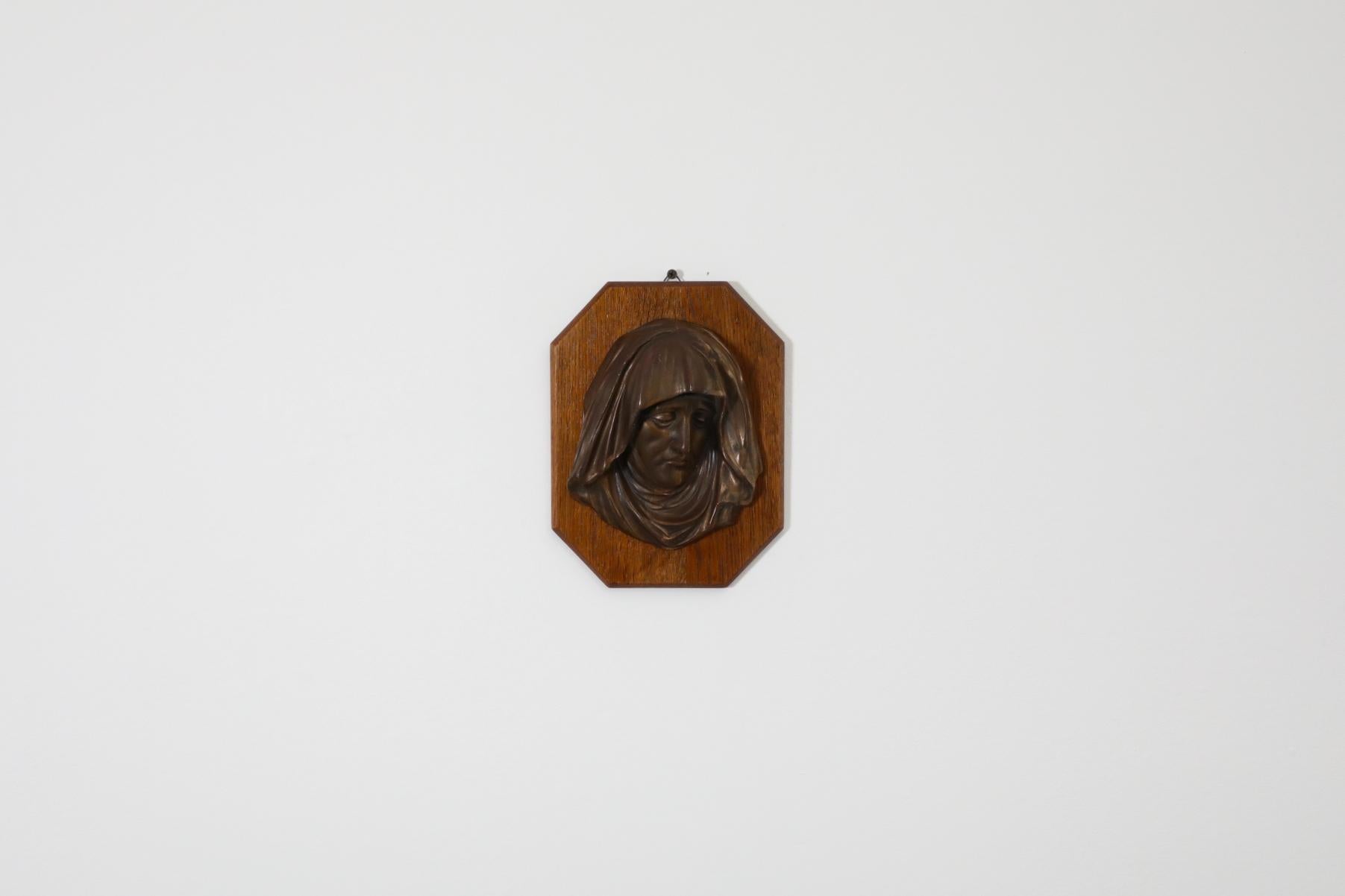 Lovely and decorative Mid-Century cast bronze relief bust of Mother Mary, mounted on oak plaque. Beautiful patina. In good, original condition. Wear consistent with its age and use.