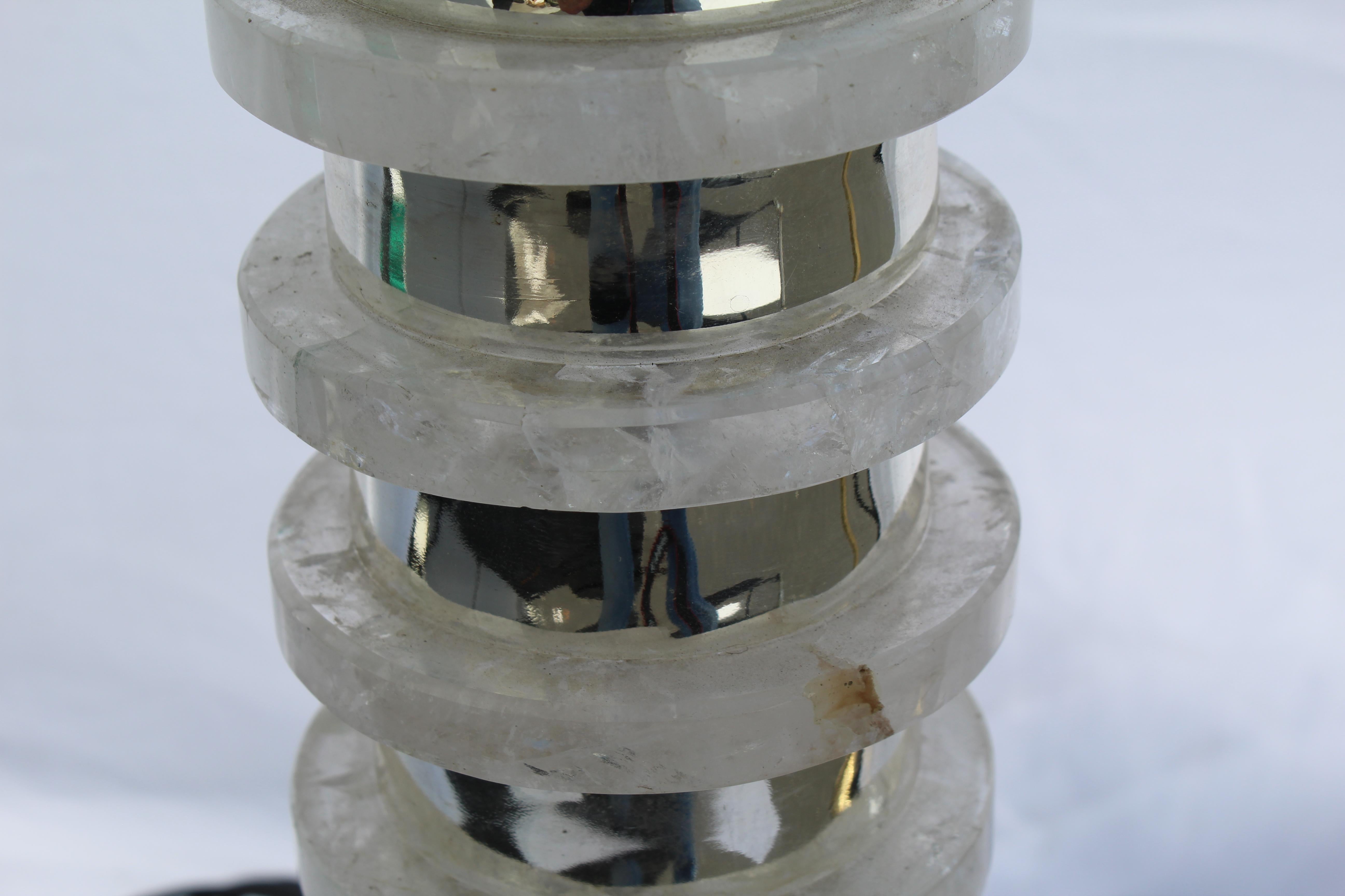 Une lampe déco/moderne faite de disques de cristal de roche empilés, fabriquée au Brésil. Chaque disque est séparé par une entretoise en métal nickelé hautement polie. Le tout est monté sur une base en marbre noir absolu de 6