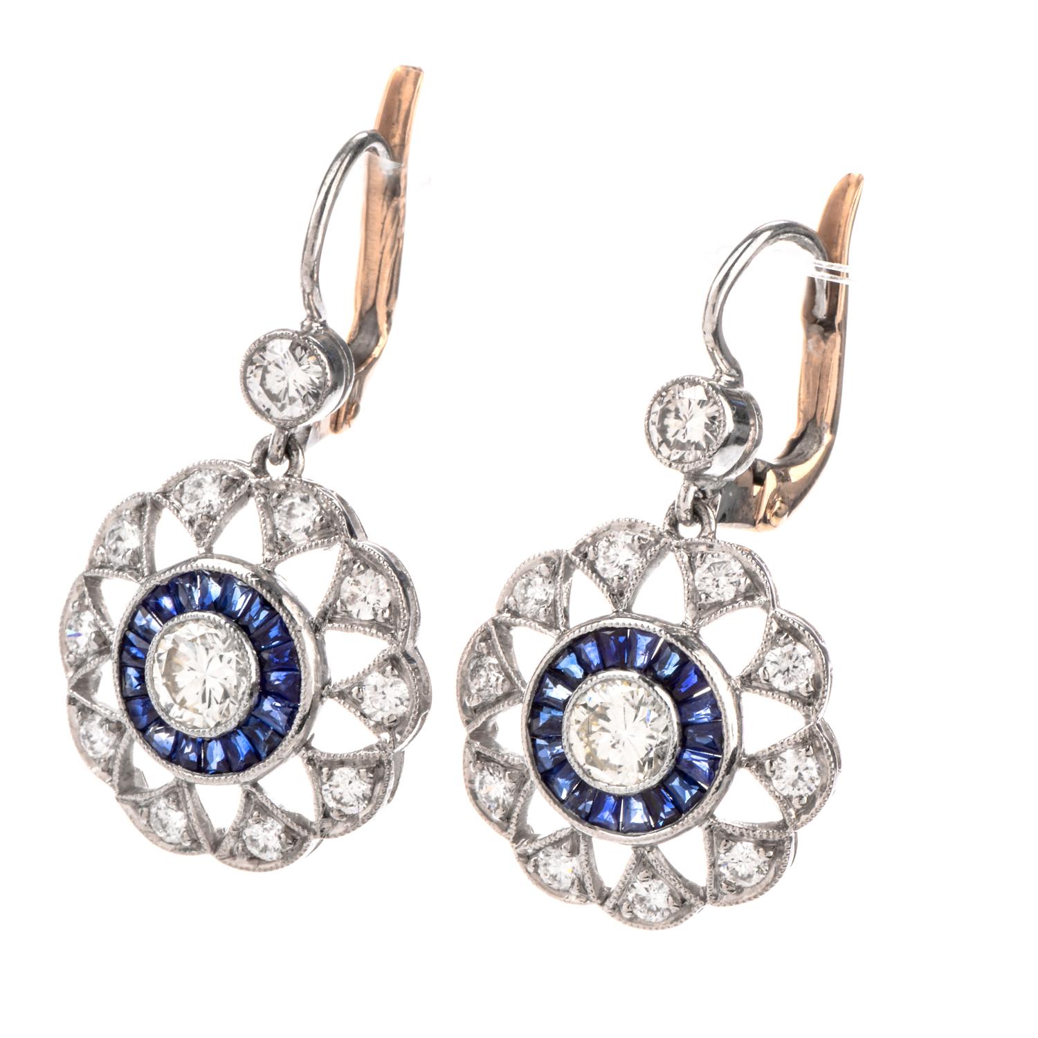 These  Diamond and Sapphire Earrings were inspired by a Pinwheel motif and crafted in Platinum with 18K Very Good condition.

A bezel set Diamond adorn the centermost area surrounded by channel set Sapphire and finally an open ring of