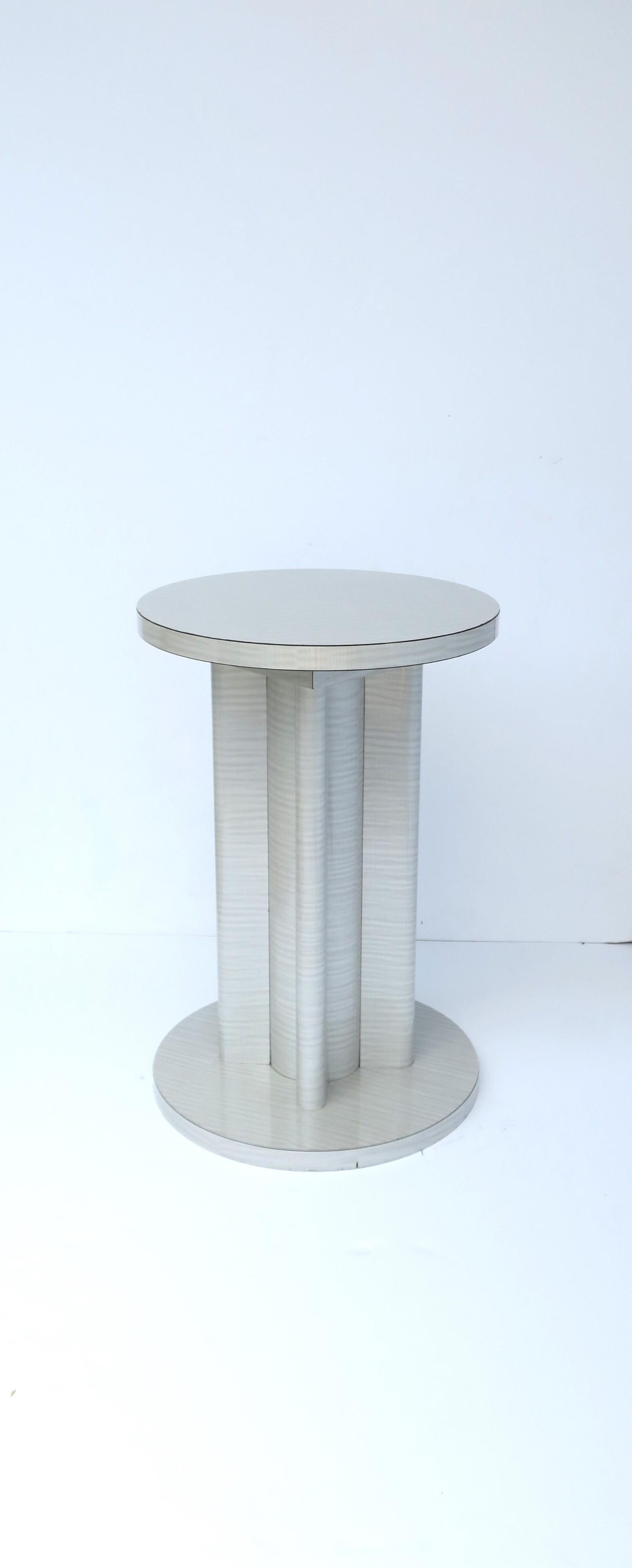 A chic round side drink Gueridon table of the Art Deco Revival '70s Modern period, in silver light-grey laminate, circa 1970s. Table is a convenient size. Dimension: 12.38