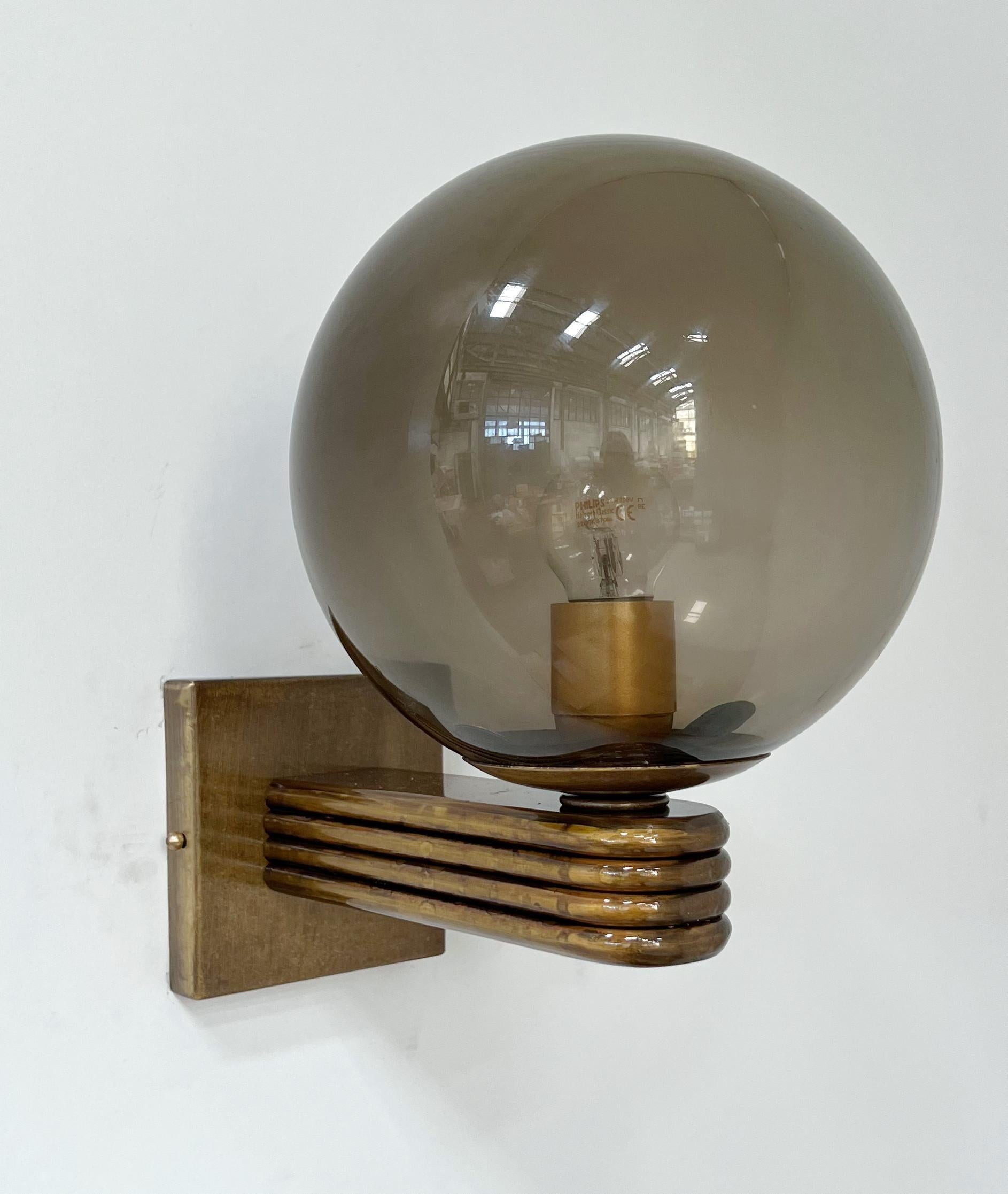 Aplique de pared italiano de estilo Art Déco con globo de cristal de Murano ahumado montado sobre marco acabado en bronce, diseñado por Fabio Bergomi para Fabio Ltd, fabricado en Italia.
1 luz / tipo E12 o E14 / máx. 40W
Medidas: Alto 12 pulgadas,