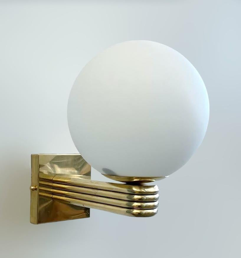 Aplique de pared italiano de estilo Art Déco con globo de cristal de Murano blanco mate montado en un marco de latón natural sin lacar, diseñado por Fabio Bergomi para Fabio Ltd, fabricado en Italia.
1 luz / tipo E12 o E14 / máx. 40W
Medidas: Alto
