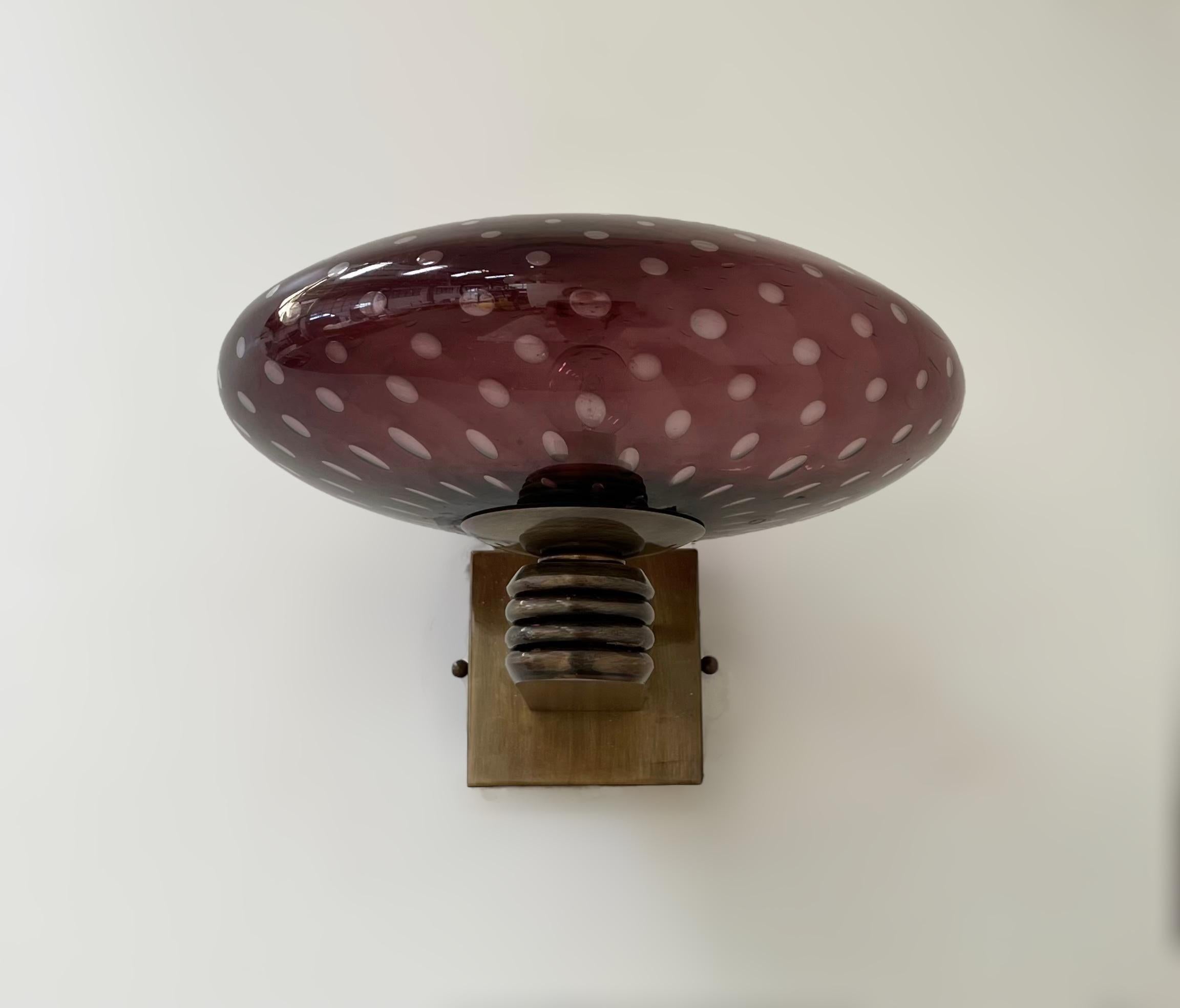 Aplique de pared italiano de estilo Art Déco con pantalla de cristal de Murano amatista soplado a mano con burbujas en el interior del cristal mediante la técnica de Bollicine, montado en marco de acabado bronceado / Diseñado por Fabio Bergomi para