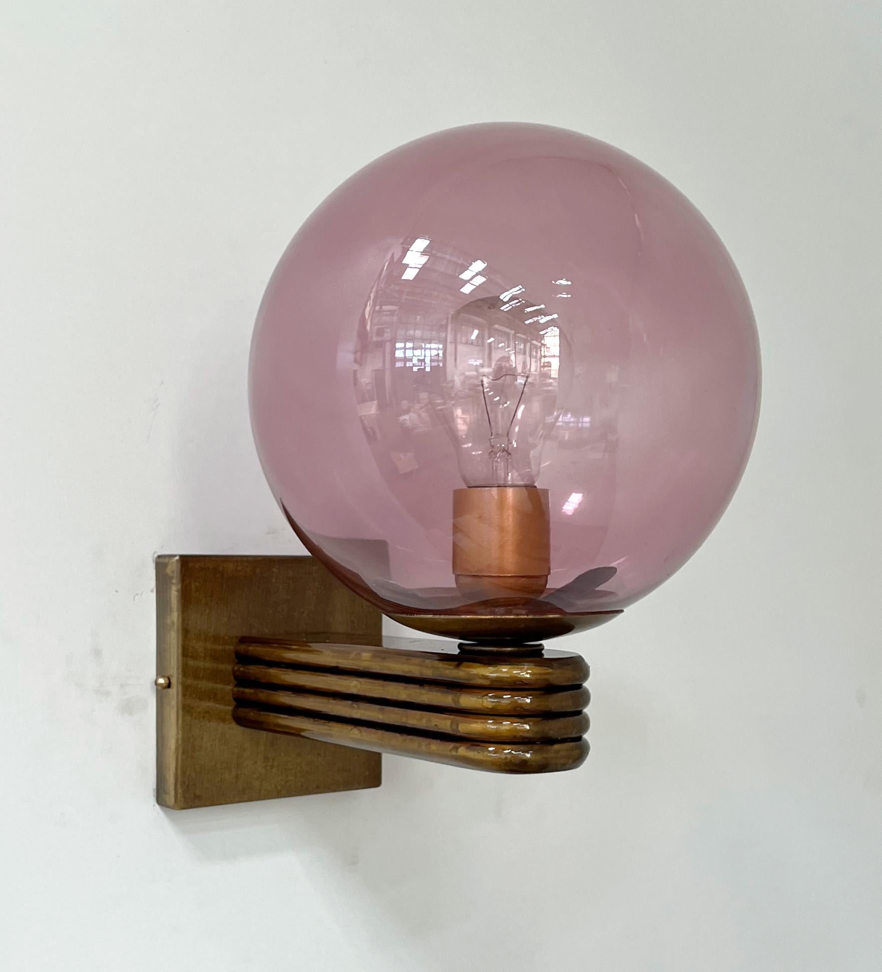 Italienische Wandleuchte im Art-déco-Stil mit einer Kugel aus transparentem Murano-Glas in rosa Koralle auf einem bronzierten Rahmen, entworfen von Fabio Bergomi für FABIO LTD, hergestellt in Italien
1 Leuchte / Typ E12 oder E14 / max 40W
Maße: Höhe