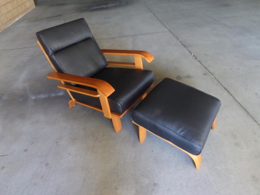 A 1950s Art Deco style solid maple lounge chair and ottoman attributed to Russel Wright for the Conant Ball Company. Both pieces have been professionally polished and the loose cushions have been newly recovered in high-quality black leather. The