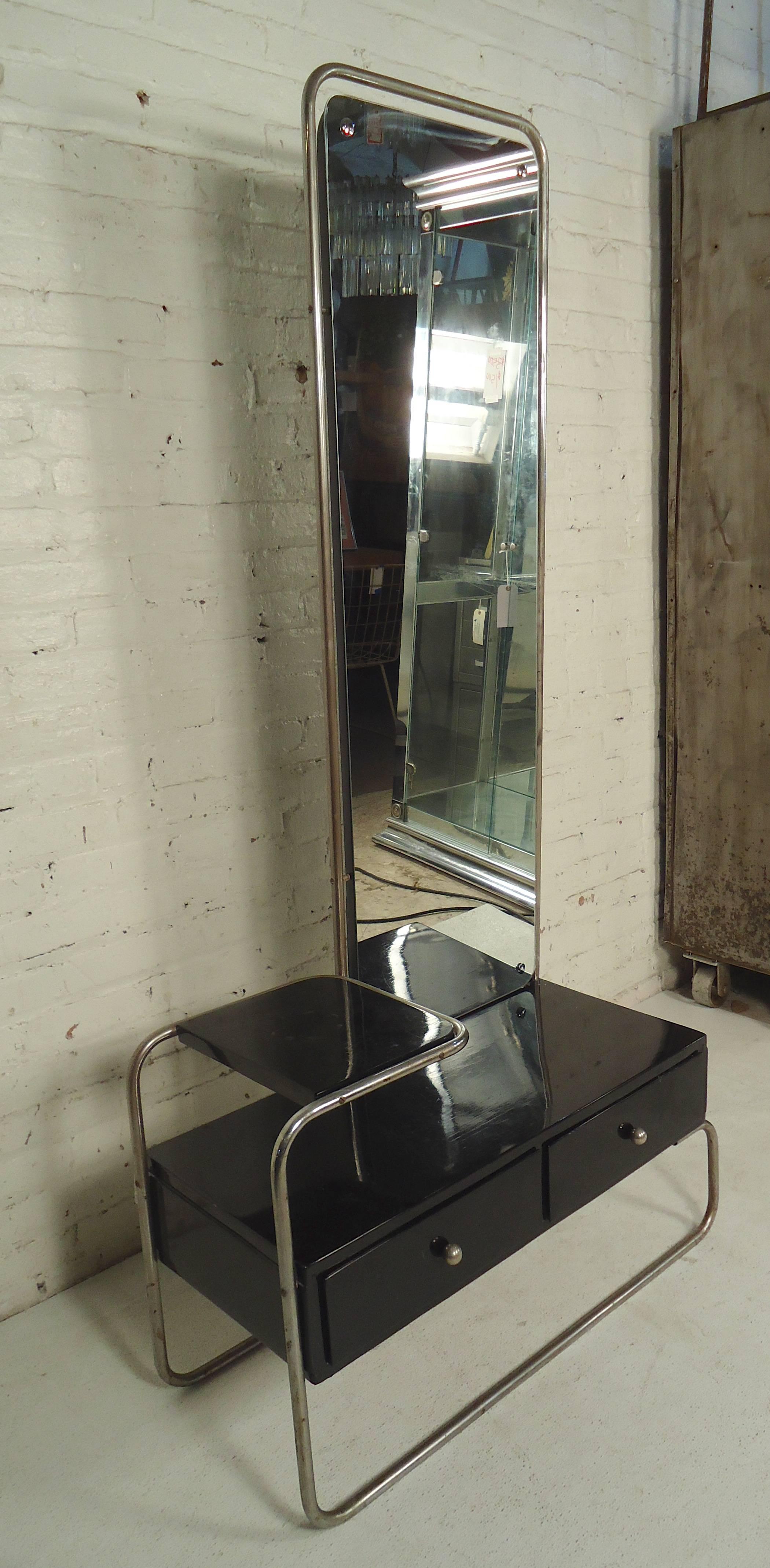 Unique tall mirror set above a black vanity table with drawers. Tubular chrome goes around the entire unit, accenting the black nicely.

(Please confirm item location, NY or NJ, with dealer)
 