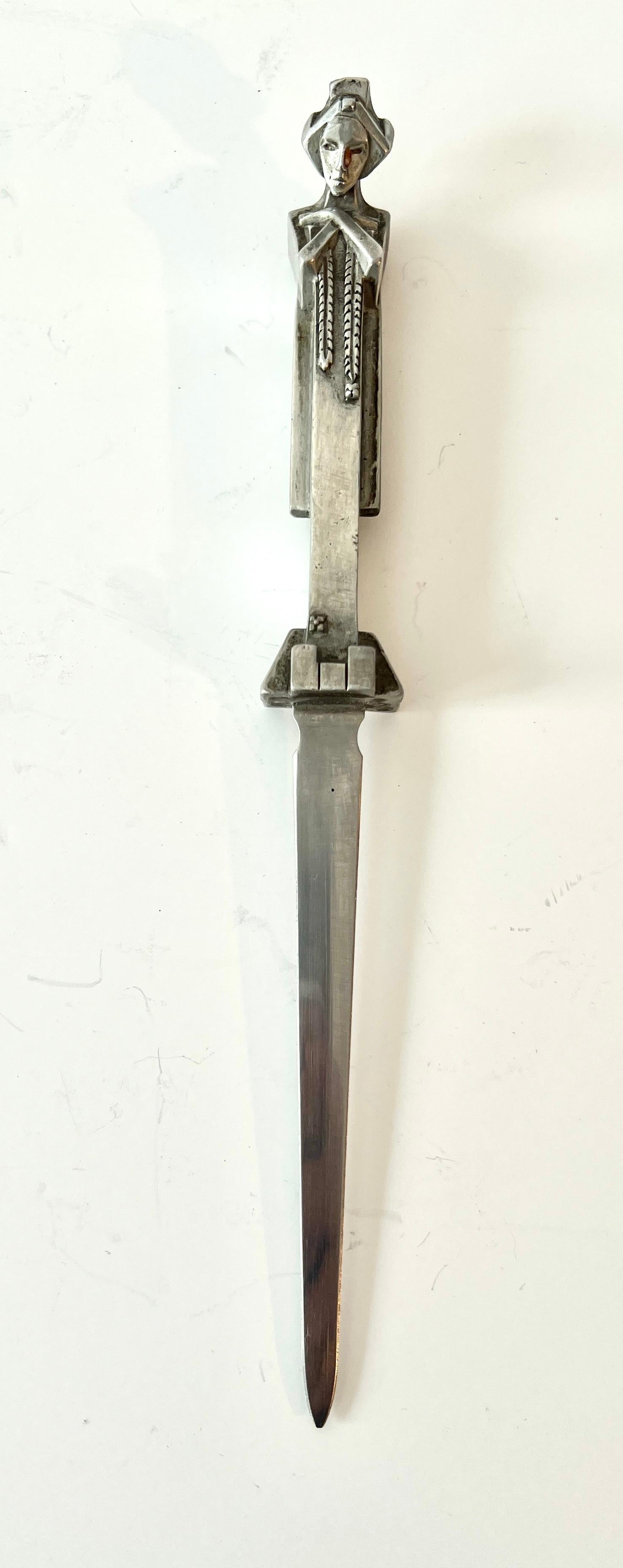 Spectacular and very unique letter opener.  Silver plate or Pewter, however it's the design that makes the piece so great.

A compliment to any desk, or work station, in a residence or sophisticated business.

One of our favorite letter openers. 