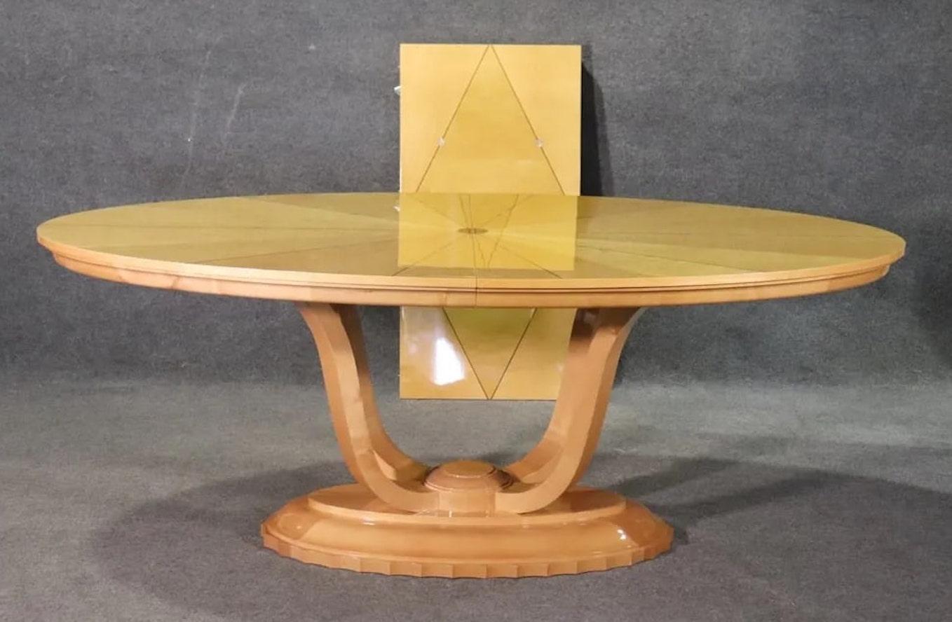 Art Deco oval dining table with leaf. Bright maple wood grain with inlay rosewood and mother of pearl. A stand out dining table. Leaf measures 22