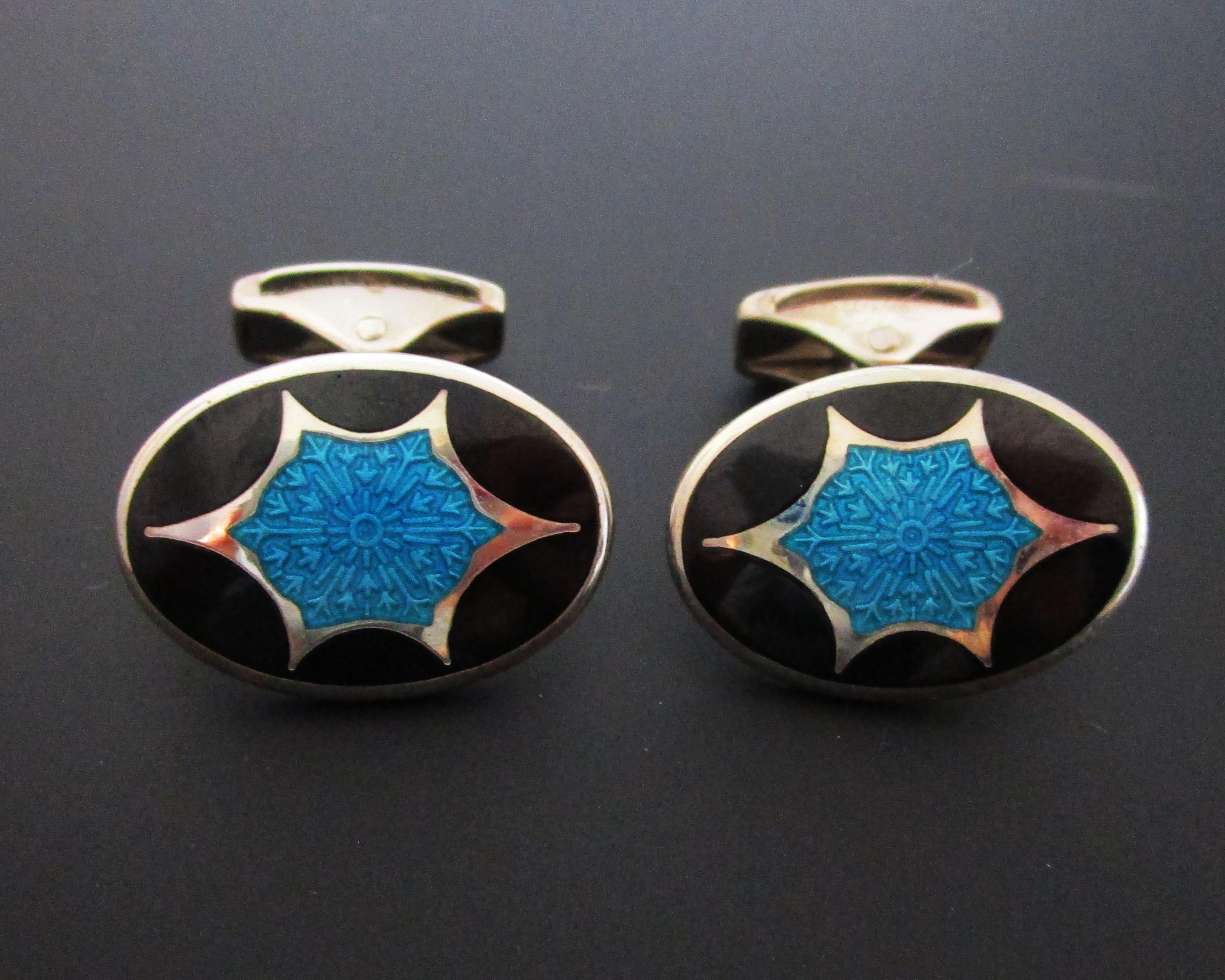 This is a remarkable pair of sterling silver Deco style cufflinks featuring gorgeous turquoise guilloche enamel field and a dramatic opaque black enamel border! The classic oval shape of the links is made unique by the dramatically contrasting