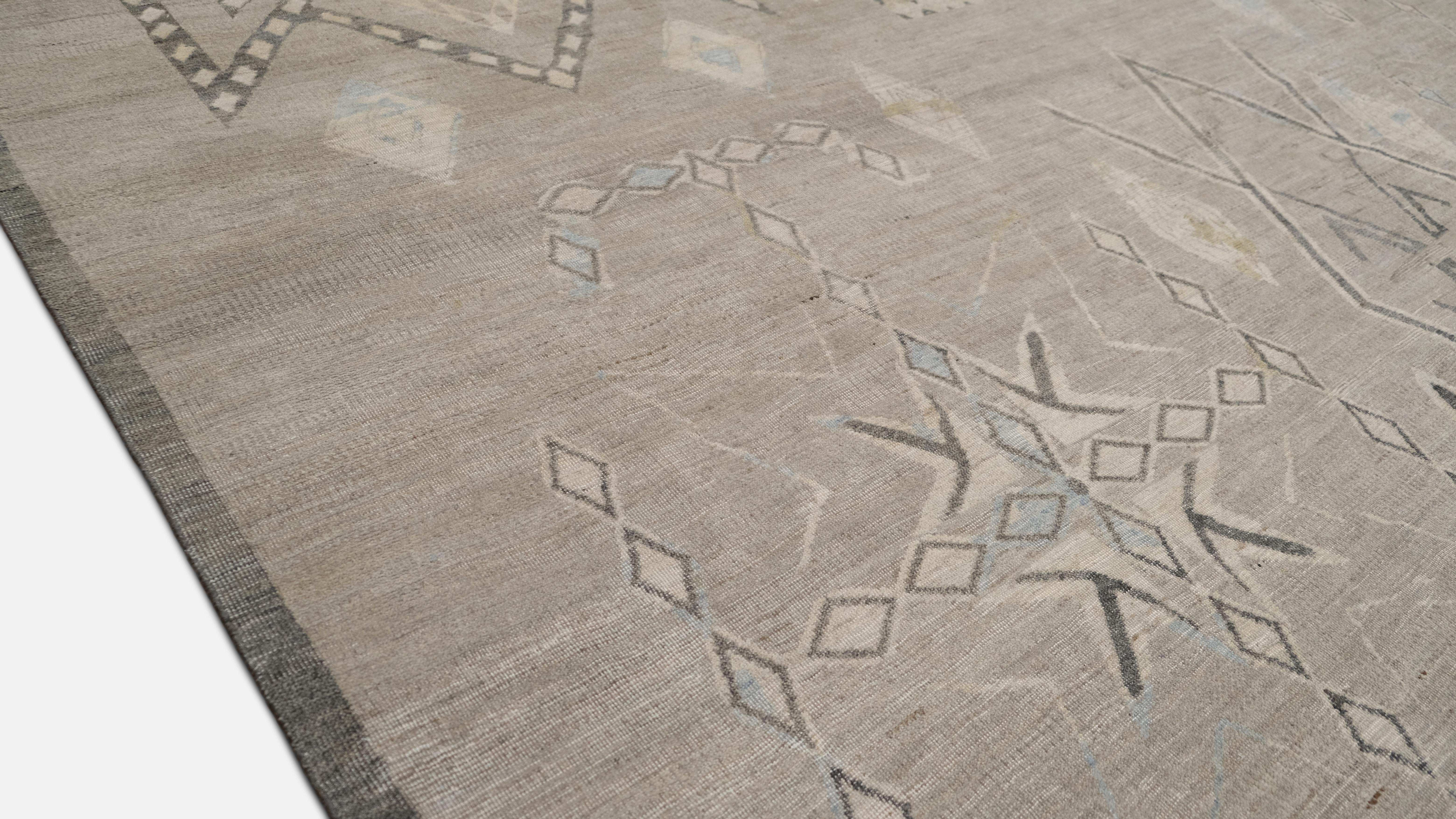 Dieser handgeknüpfte Wollteppich zeigt ein von Stämmen inspiriertes geometrisches Design mit einem raffinierten zeitgenössischen Touch. Mit seiner subtilen, neutralen Farbpalette aus Beige, Grau und Elfenbein ist dieses Stück eine perfekte Mischung