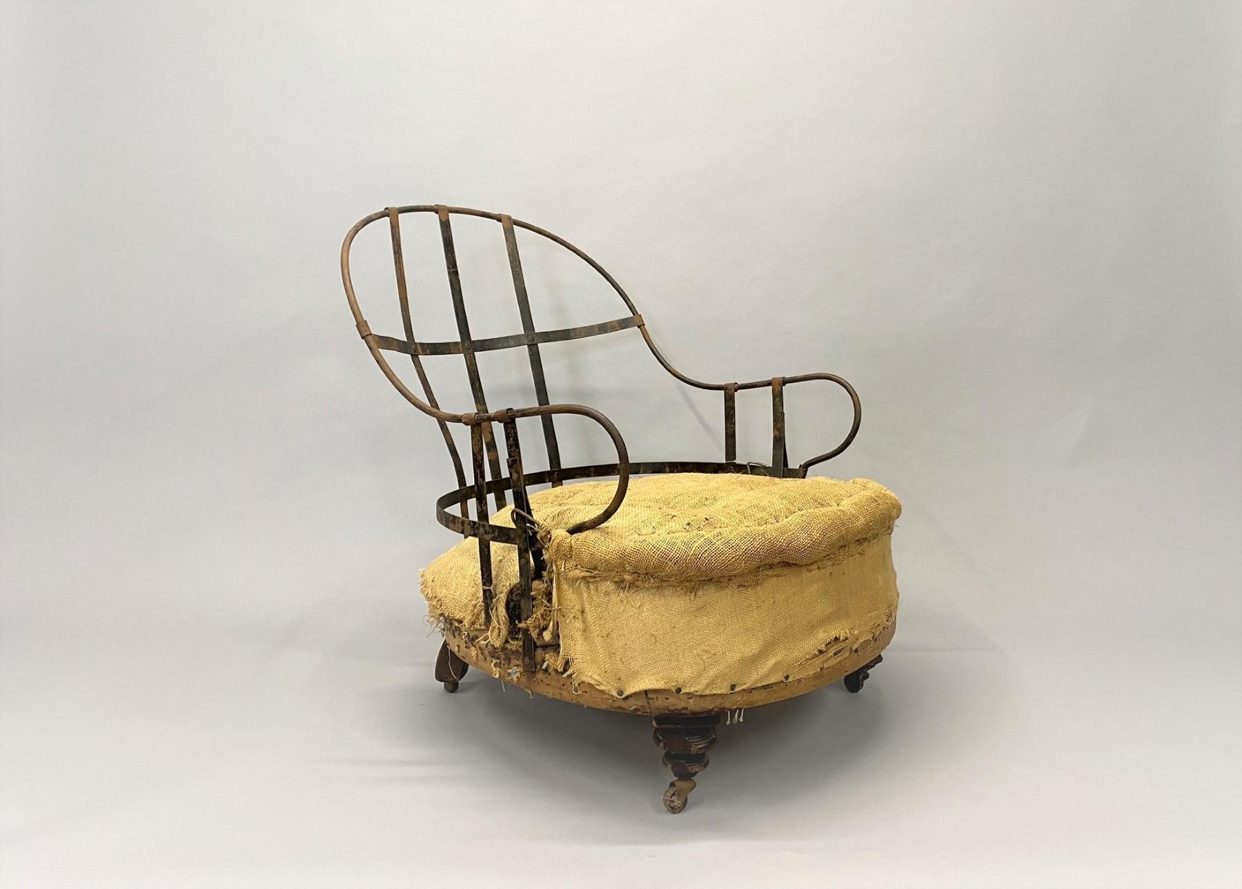 Charmant fauteuil de cheminée ancien à cadre apparent et haut dossier en fonte datant du milieu des années 1800.   La chaise a été déconstruite pour révéler le magnifique cadre en fer et l'assise en toile de jute.   Le dos en fer original est