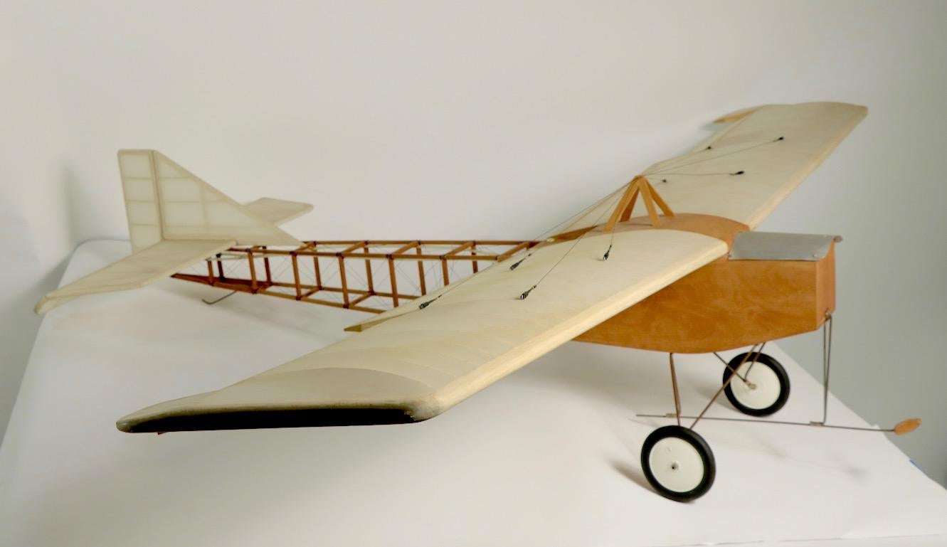 Skeletal model of small aircraft having an exposed balsa wood frame, with stretched membrane skin (think Nelson bubble fixture ), X-pattern thread cables, some of which are torn, see images, and metal mounted wheels. Wonderful architectural form,