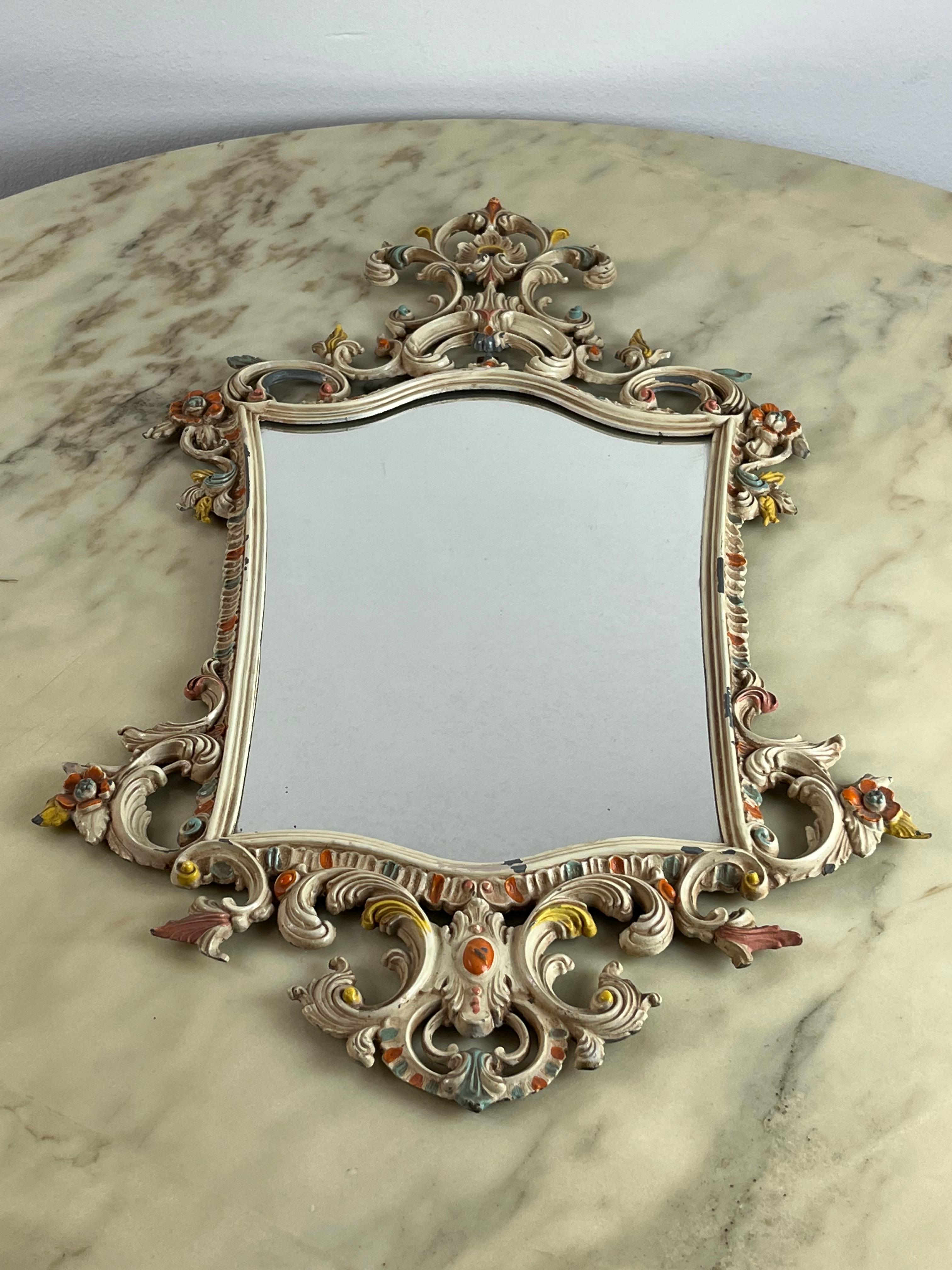 Decorated bronze wall mirror, Italy, 1970s. It has some small lacks of paint. In need of a minor restoration.