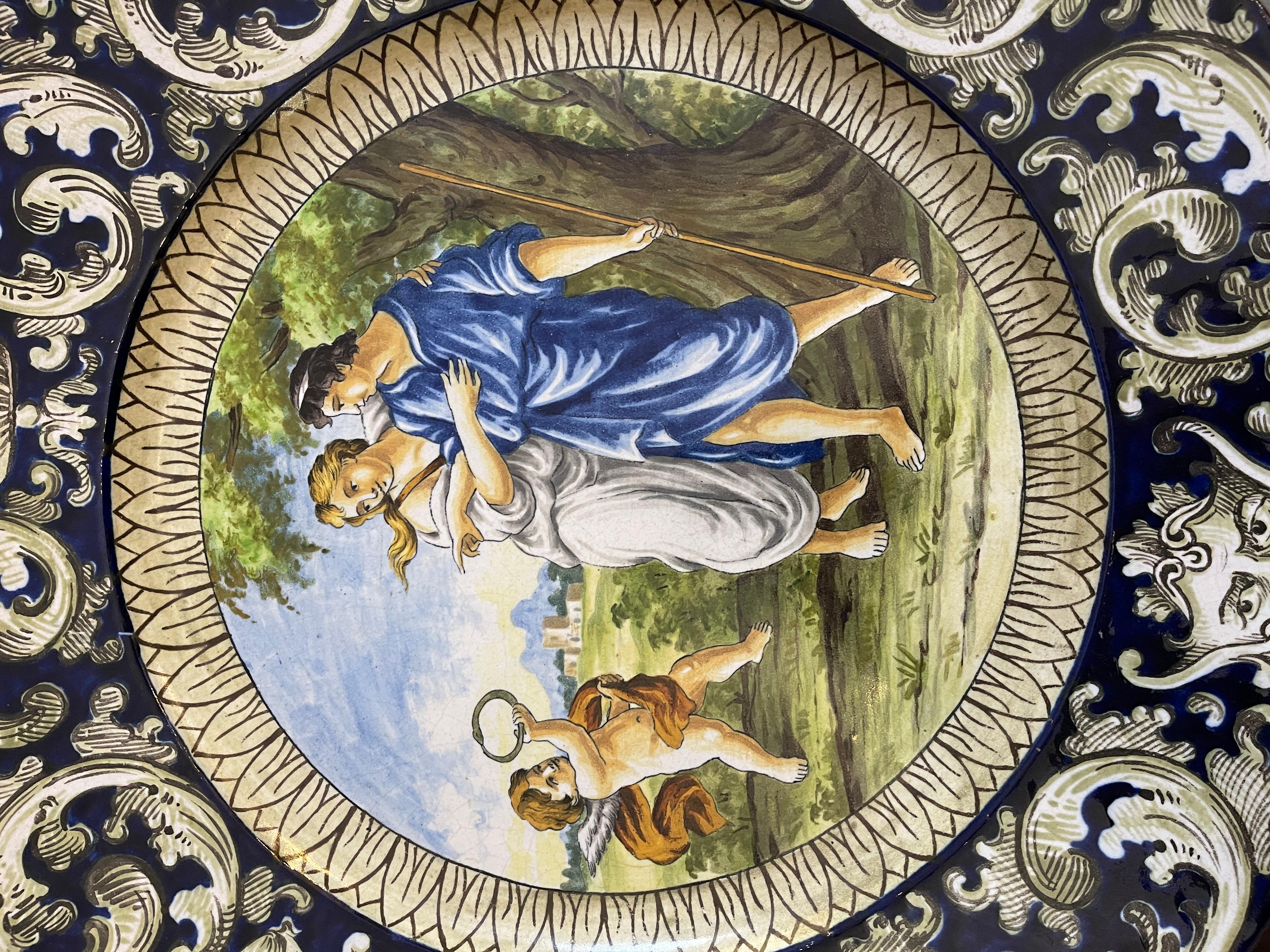 Decorated ceramic plate, 19th century, mythological scene
Large ceramic plate, decorative object with hook to be mounted on the wall, made in the first half of the 19th century, depicts a mythological scene, decoration along the edges typical of the
