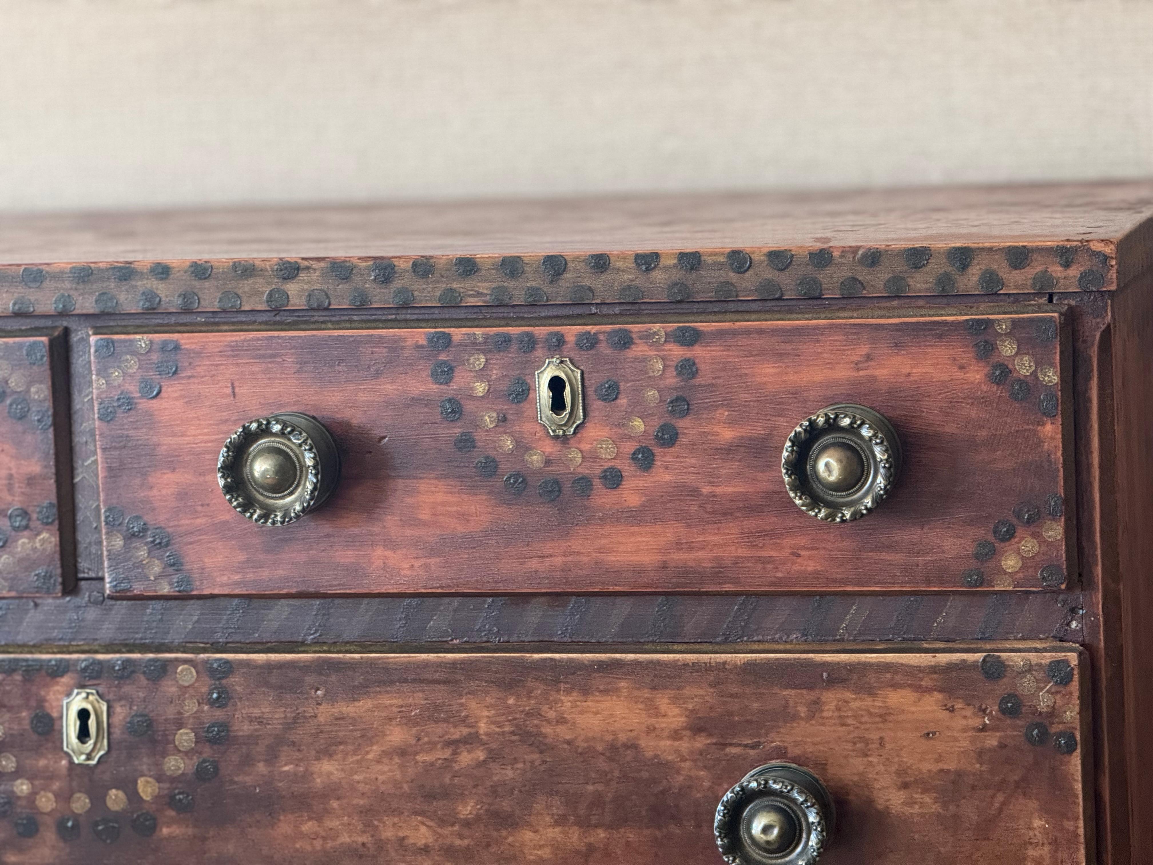 Beautiful chest of drawers made of pine and retaining the original red painted finish with polka dots in dark green and yellow. Period brass hardware. Pennsylvania, dated on inside, 
