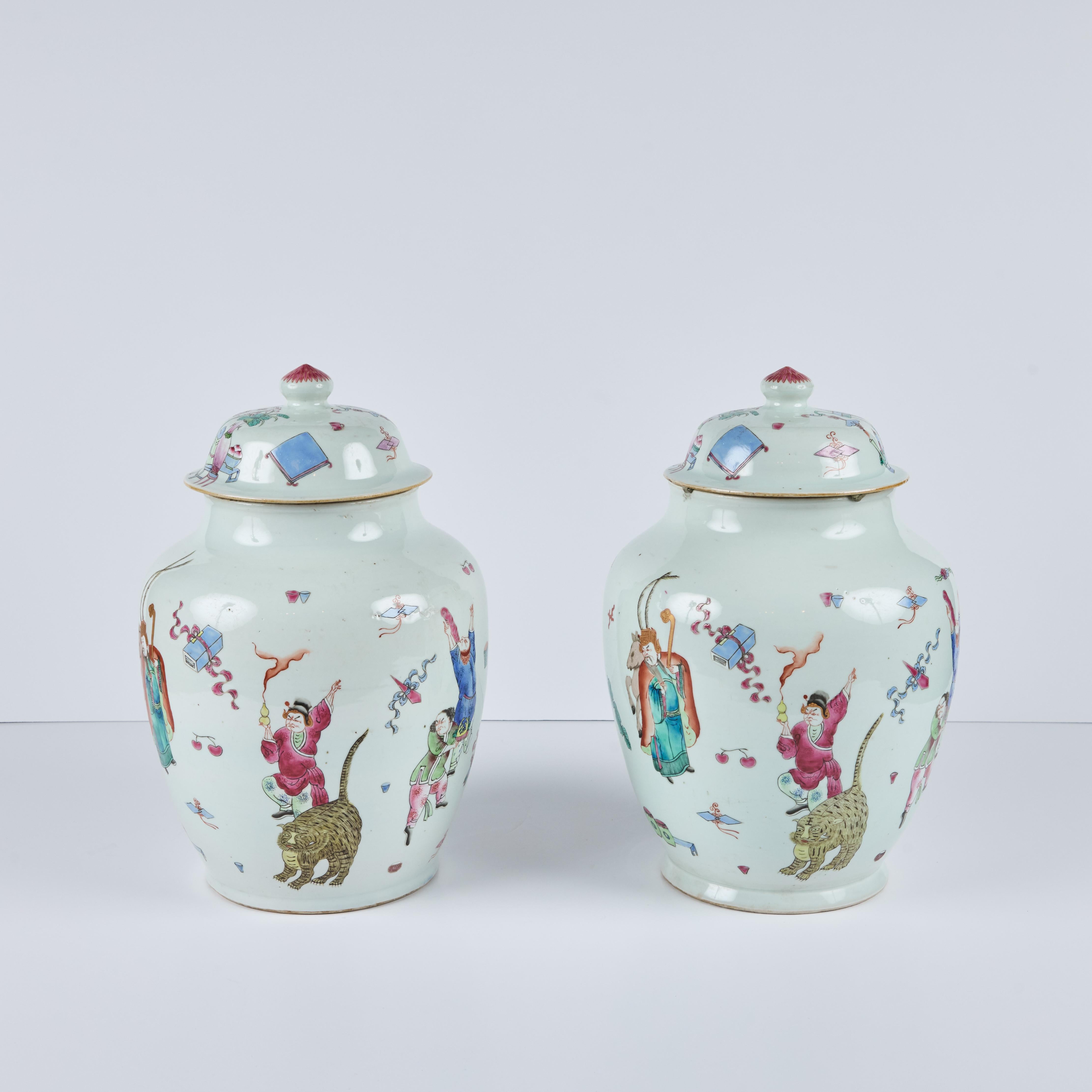 Ein Paar chinesische, handbemalte, farbenfrohe Porzellandosen mit Deckel, die festliche Szenen mit Figuren und Tieren zeigen.  
