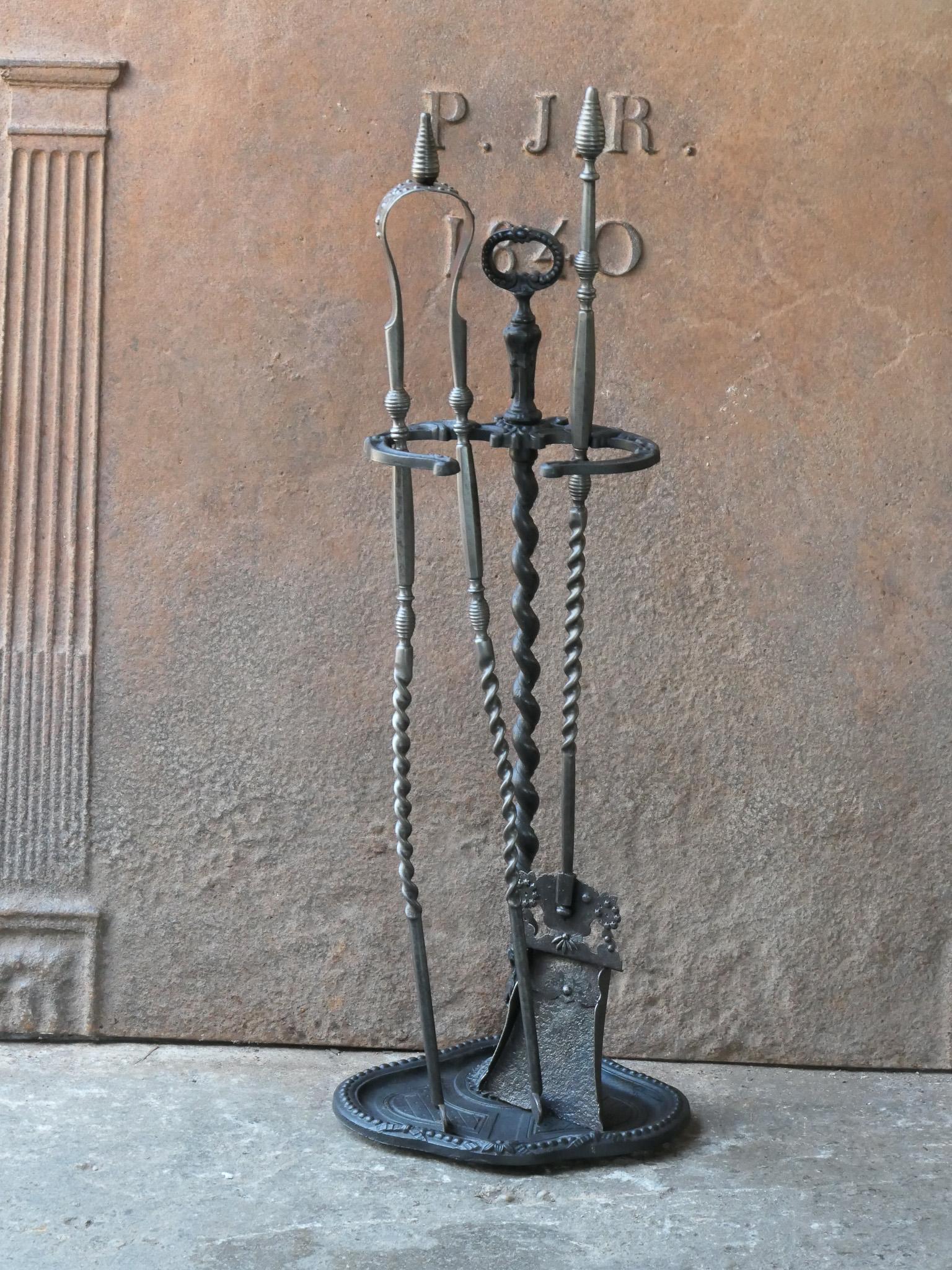 19th century French fireplace tool set. The tool set consists of tongs, shovel, and a stand. The exceptionally decorated tools are made of wrought iron and the stand of cast iron. The set is in a good condition and fit for use in the fireplace.