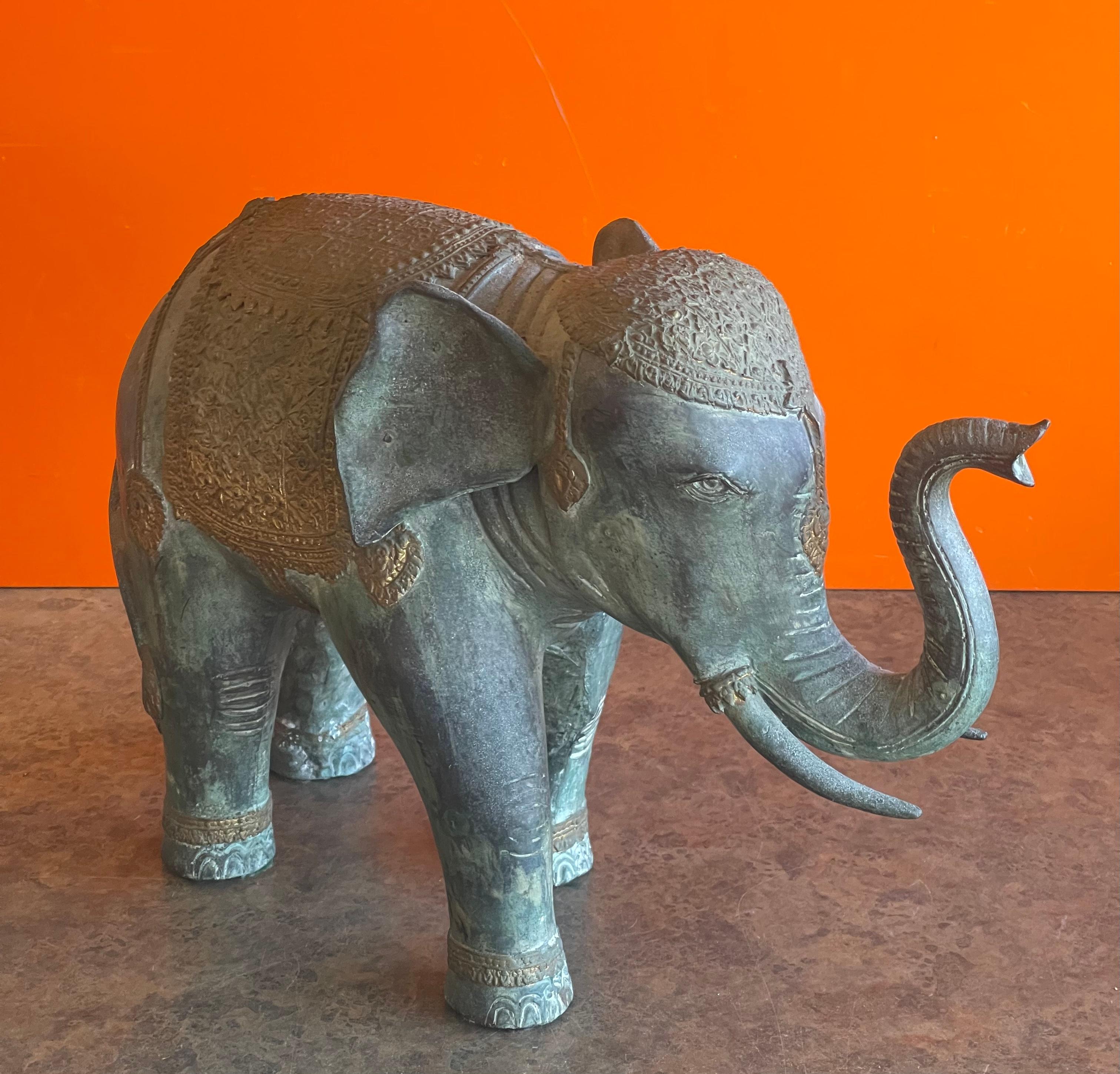 Well casted decorated Indian elephant bronze sculpture, circa 1970s. The elephant is in full gold and copper nettipattam with trunk up. The piece is in very good vintage condition and measures 15