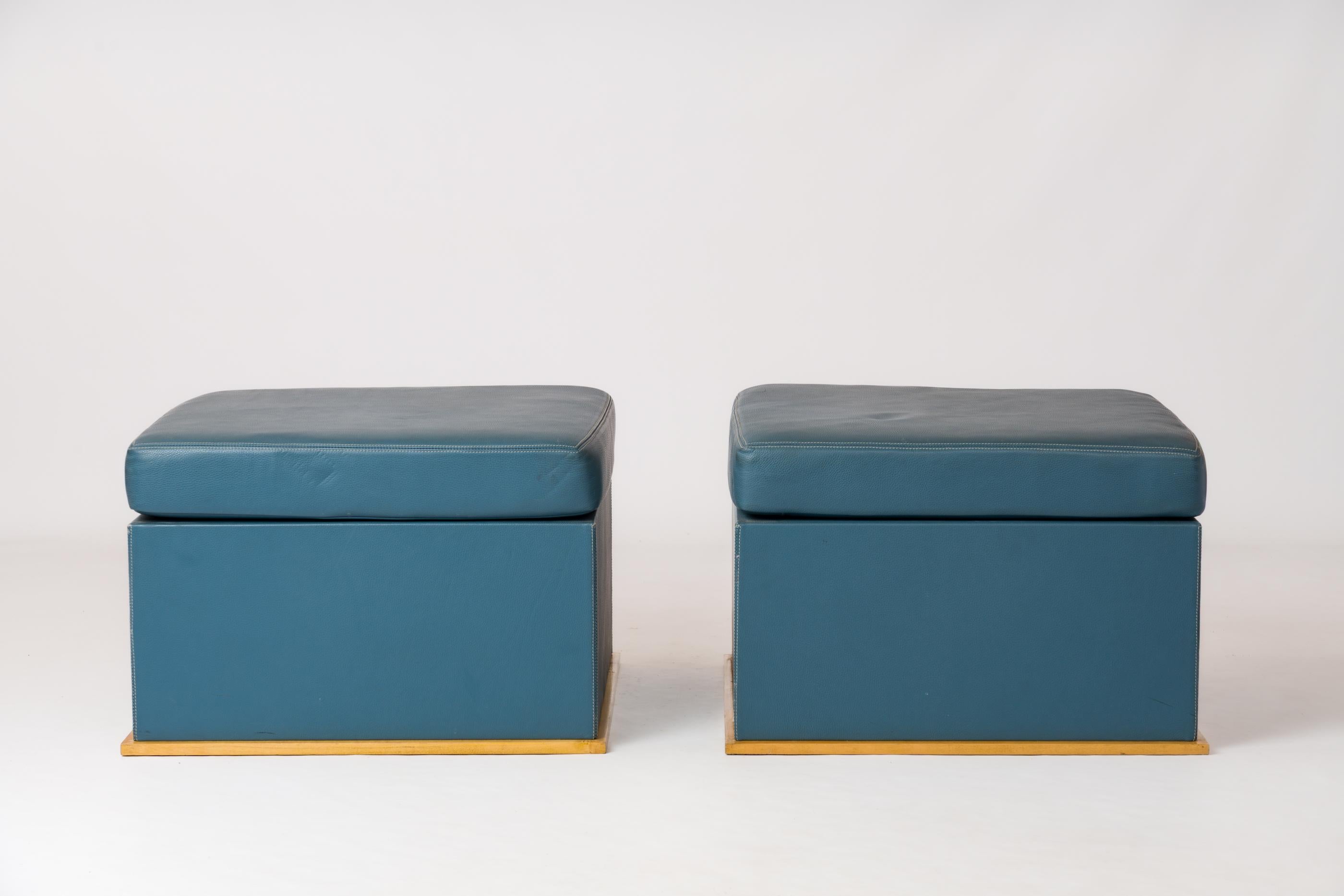 Paire de poufs en cuir bleu avec surpiqûres sur une base en sycomore, dans le style d'Hugues Chevalier. France Années 1980.
En bonne condition vintage. Petites rayures superficielles, taches et éraflures sur le cuir et le bois.
Ces ottomans sont