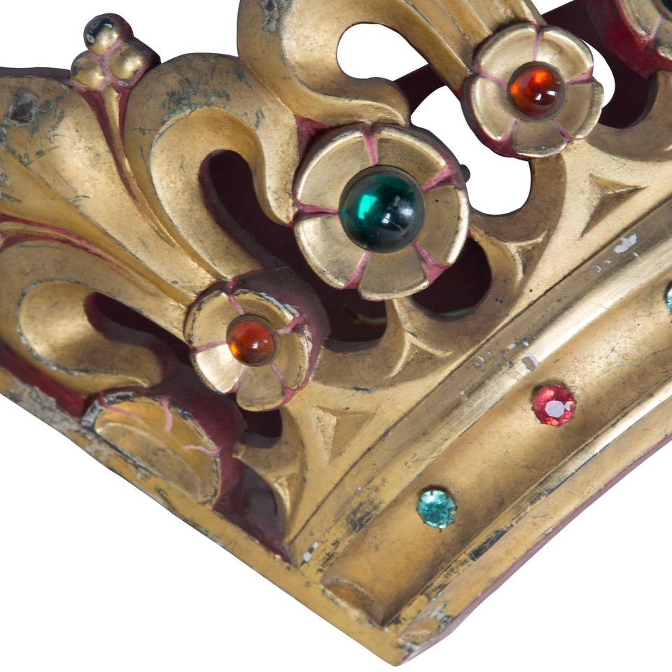 This 19th century decorative coronet crown is made of carved wood and gilt, with inlaid glass-colored cabochon all around the sides. This piece has a flat backing allowing for it to be hung on a wall. This piece has been converted to use as a wall