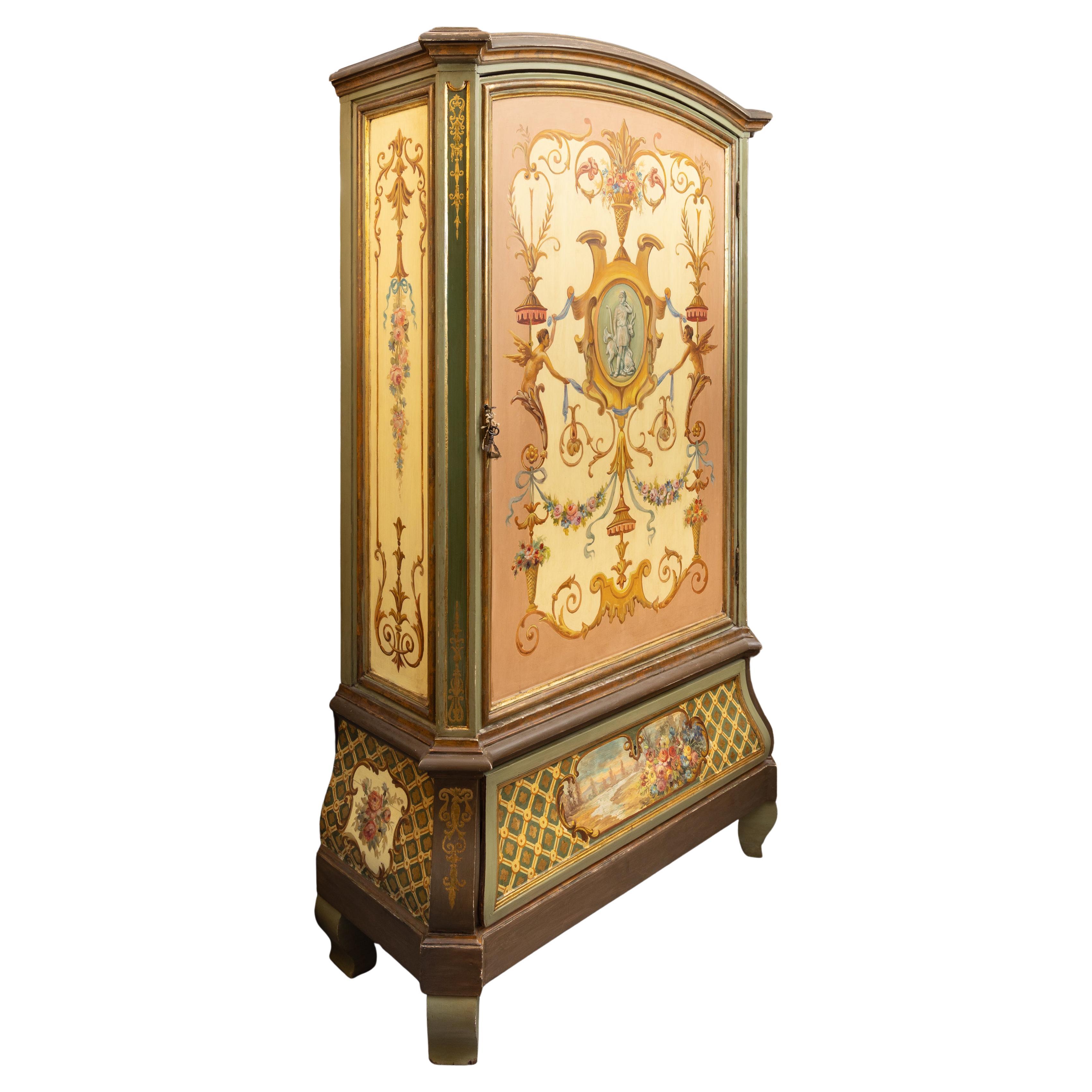 Si tratta di un armadio decorativo del XIX secolo, con motivi classici dipinti a mano su sfondo verde.  La parte superiore ad arco si trova sopra una grande porta singola.  La parte inferiore ad arco contiene un grande cassetto estraibile.