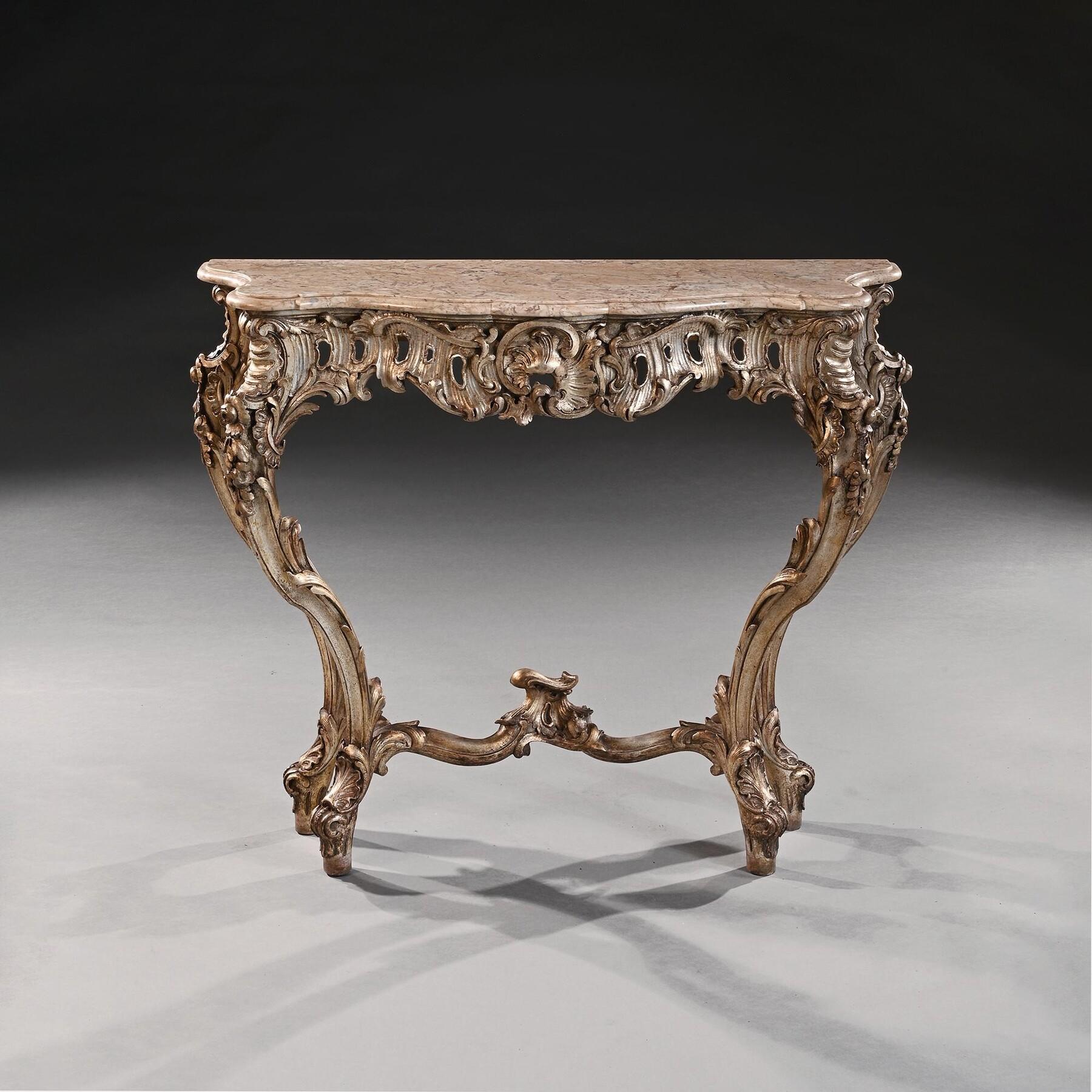 Consolle decorativa italiana dorata in argento del XIX secolo con piano in marmo sagomato

Italiano circa 1880

Di sontuosa forma rococò, questa raffinata consolle è incentrata su un cartiglio, circondato da intagli a volute. La combinazione di