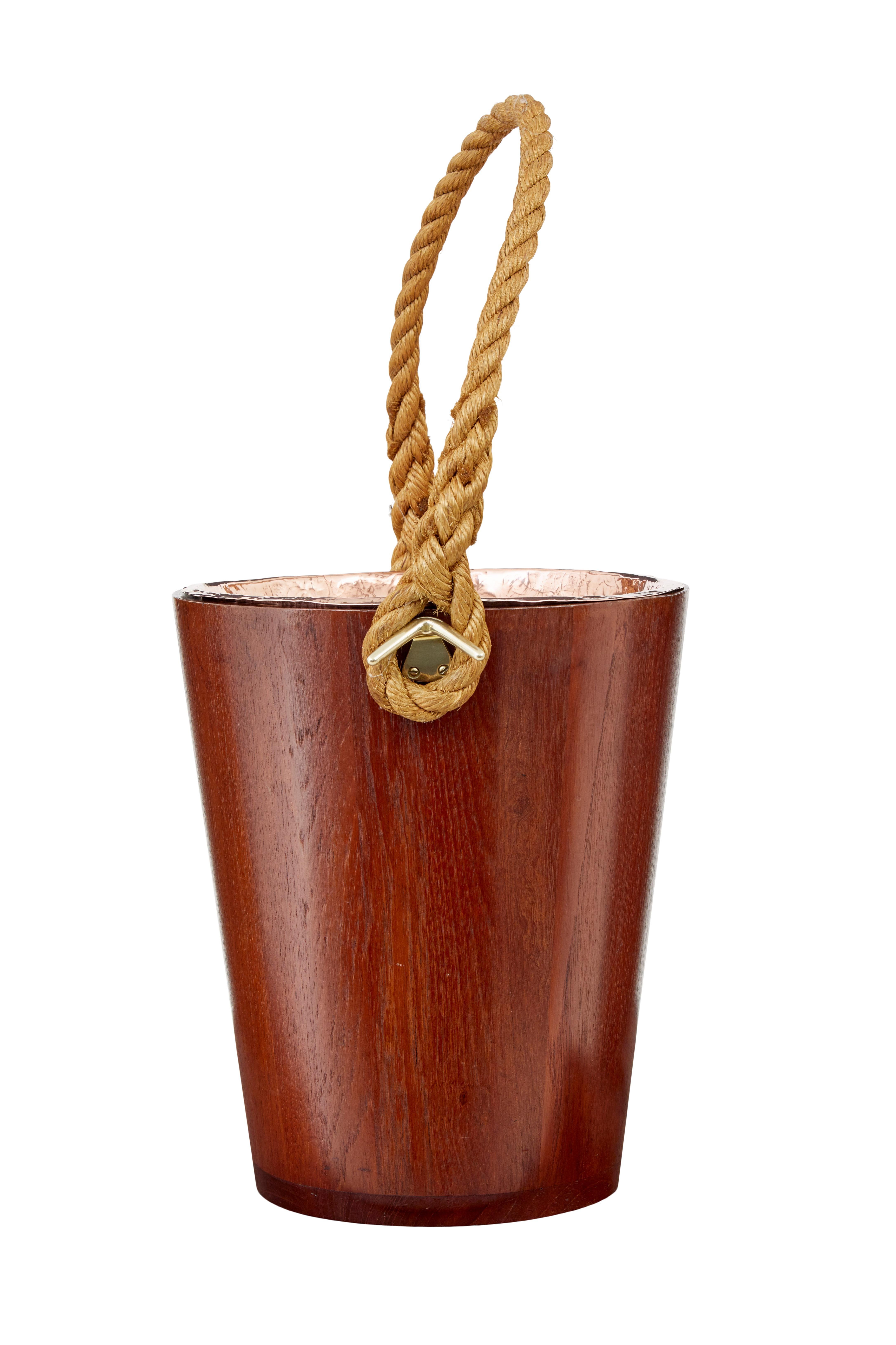 Decorative 20th century teak bucket with rope handle circa 1950.

Ideal for use as a waste paper basket or a kindling bin beside the fire.  Teak bucket with removable copper dish.

Minor surface marks.
