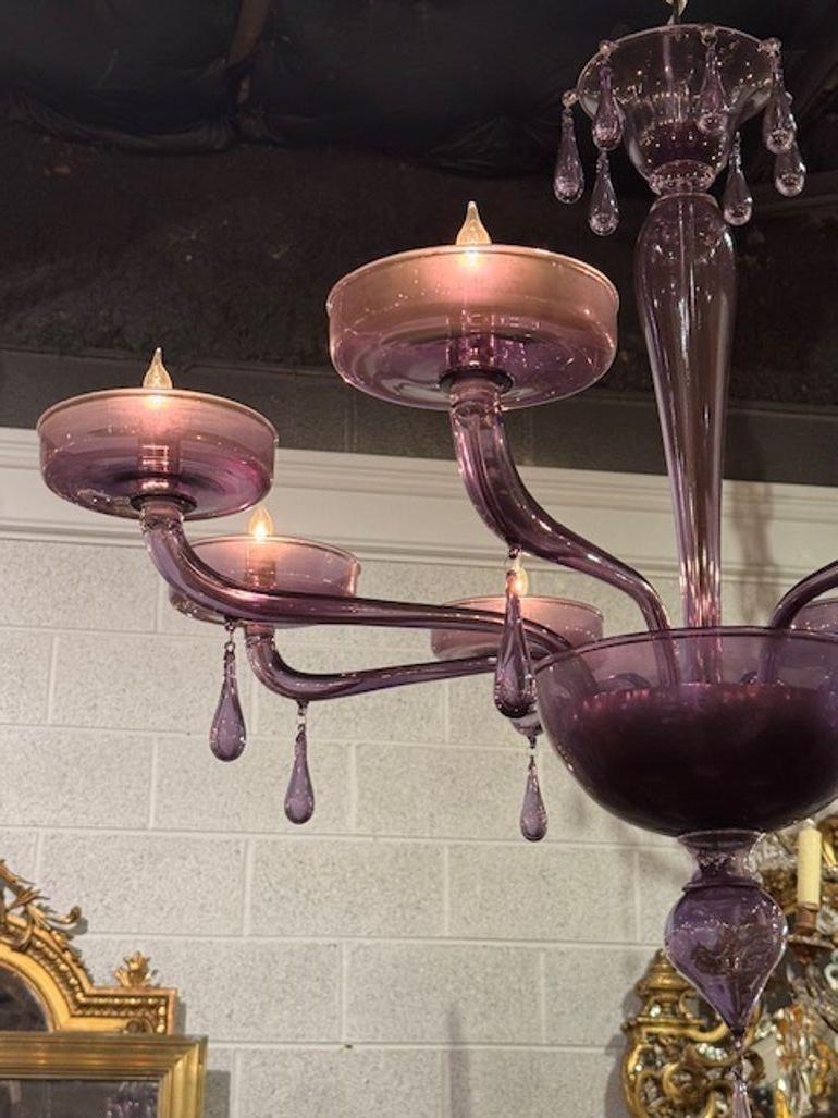 The product is a decorative 8 arm lavender Murano chandelier, which adds a stylish touch to any room. Made with intricate glasswork, this chandelier exudes elegance and sophistication. Perfect for creating a warm and inviting atmosphere in your