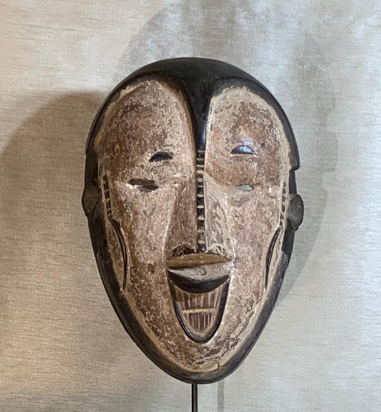 Exceptional hand carved wood mask with graphic elements, made of single piece of wood and was made for decorative purpose. Very intriguing and mysterious face.
The mask in mounted on custom made steel base.
Size without base is: 13” high x 9” wide