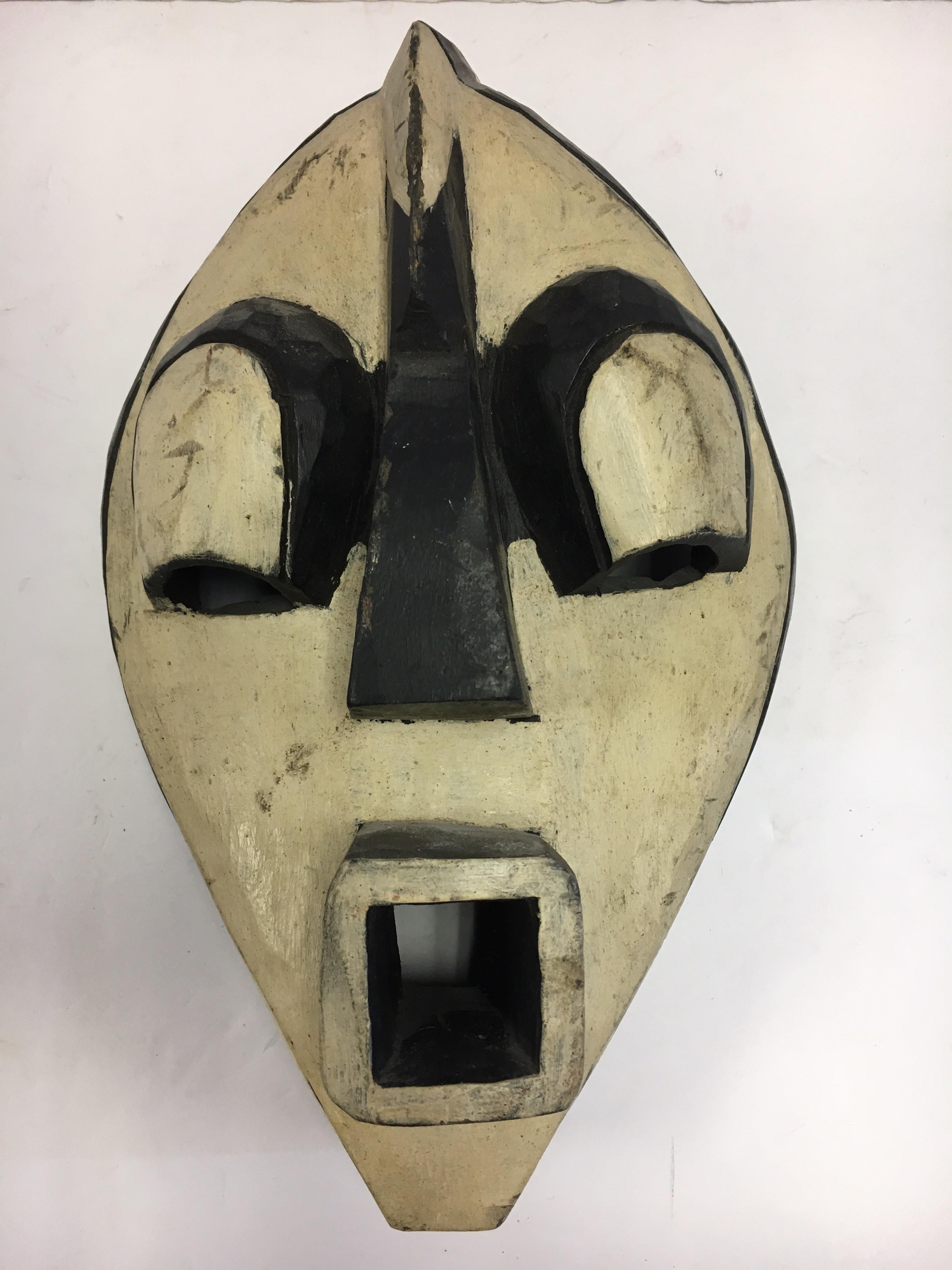 Coveted decorative African hand-carved wood mask with graphic elements, circa 1970s.
This is a decorative item from the 1970s, it was made for export, it is not an antique tribal mask.
It was made by a master carver from a single piece of wood and