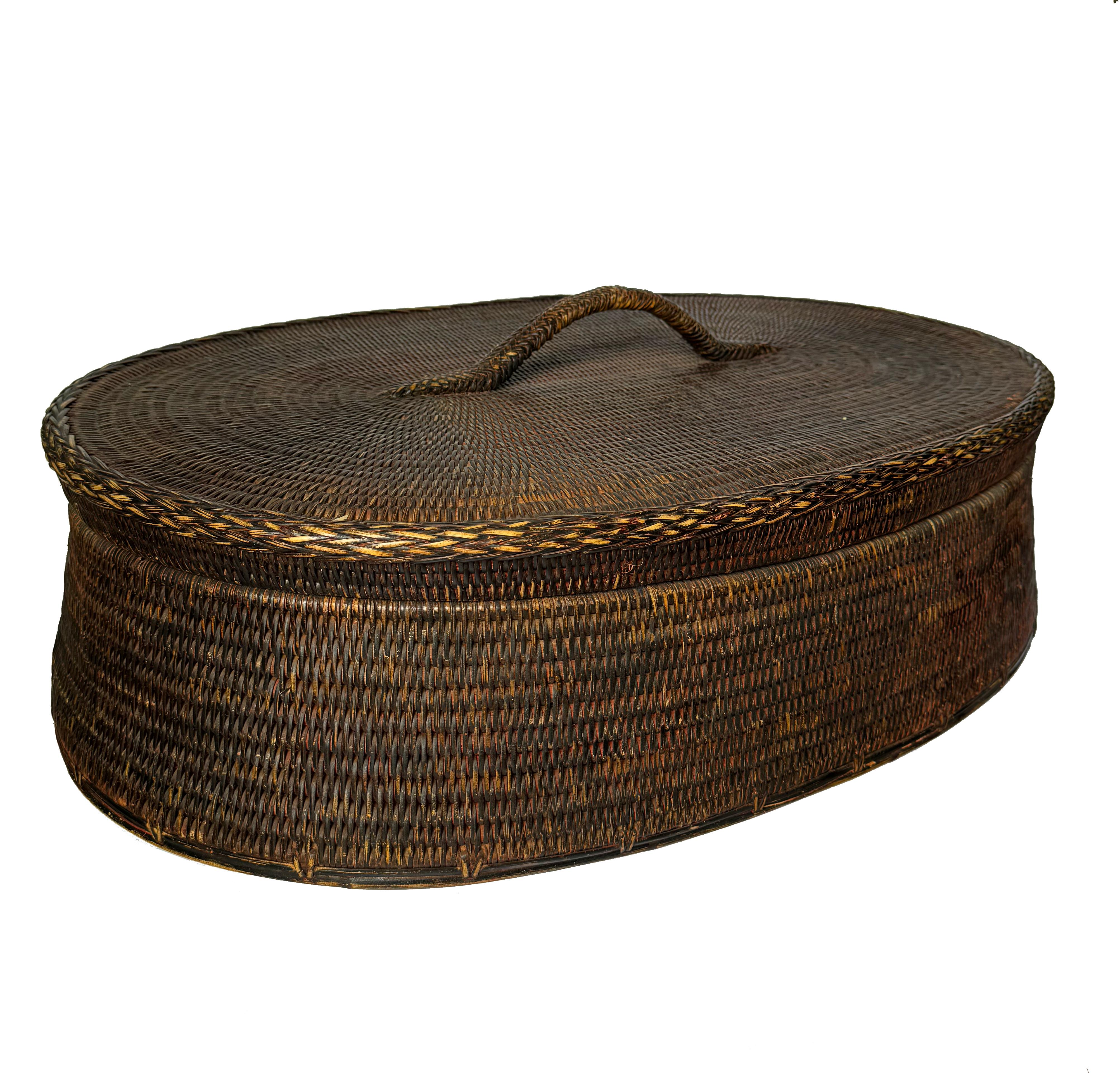 Dieser charmante quadratische Korb aus Rattan und Holz wird in Burma hergestellt. Sein rustikaler Reiz liegt in den kunstvoll gewebten Stoffen, die dem schlichten, aber eleganten Design Charakter verleihen. Ob im Schlafzimmer oder im Wohnzimmer,