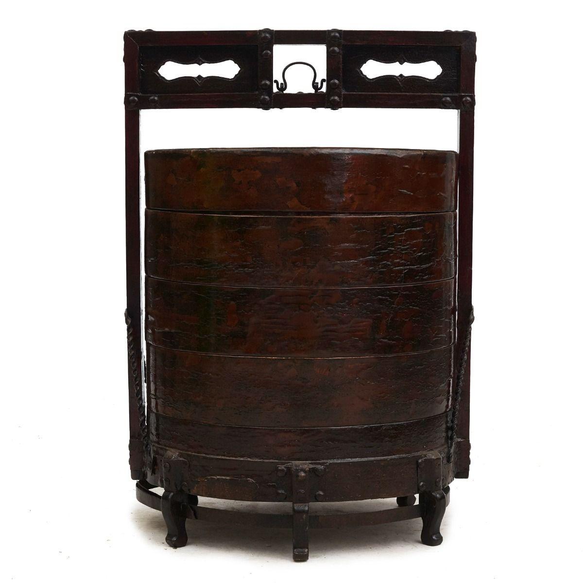 Una caja apilable portátil con cinco niveles separados, fabricada en madera de tilo y recubierta originalmente de laca negra. Aún se aprecian restos de laca, lo que confiere al recipiente una pátina impresionante, realzada por el acabado lacado de