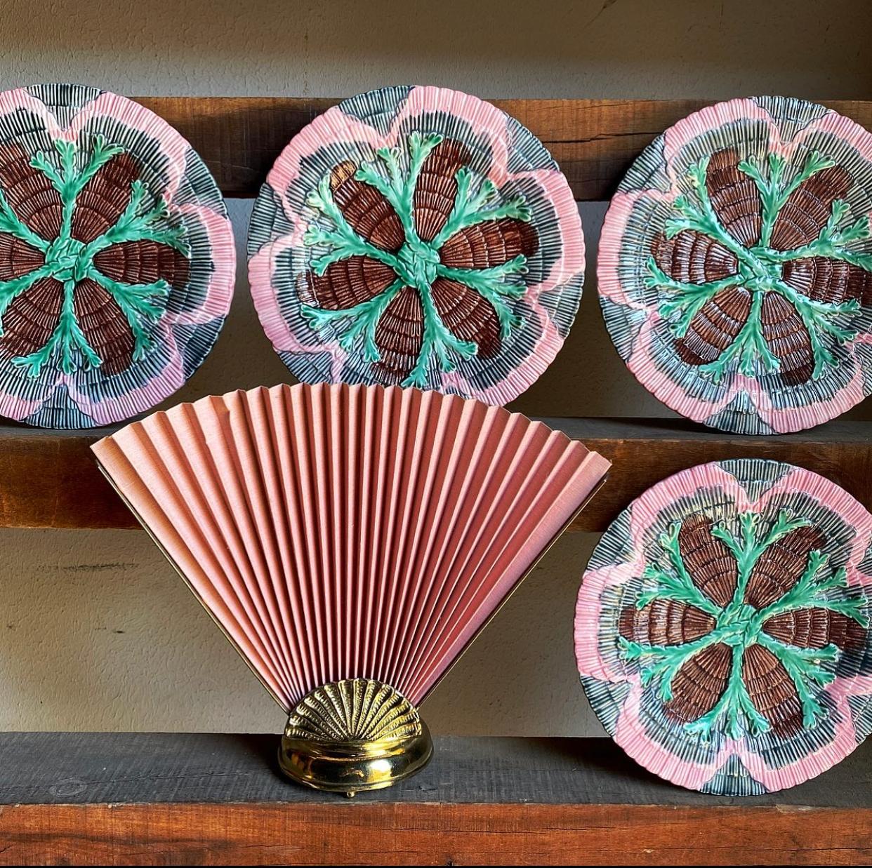 A set of four antique majolica Etruscan plates. Created from ceramic, and glazed in bright pinks, greens, browns, and blacks. Each dish has a fabulous texture and resembles the look of the cult favorite oyster plates that are often hung in groupings
